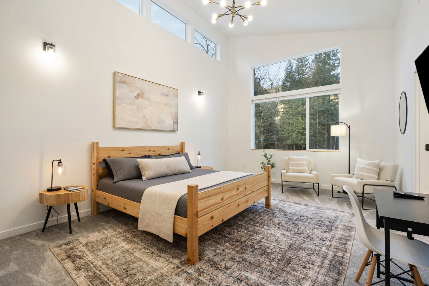 A cozy modern bedroom with a grey upholstered bed and wooden side tables