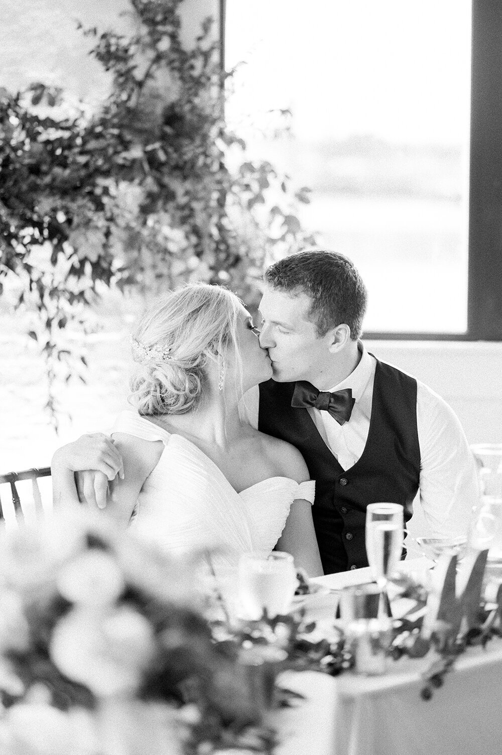 Bride and groom sharing a kiss after being toasted to at their reception at Loft 310