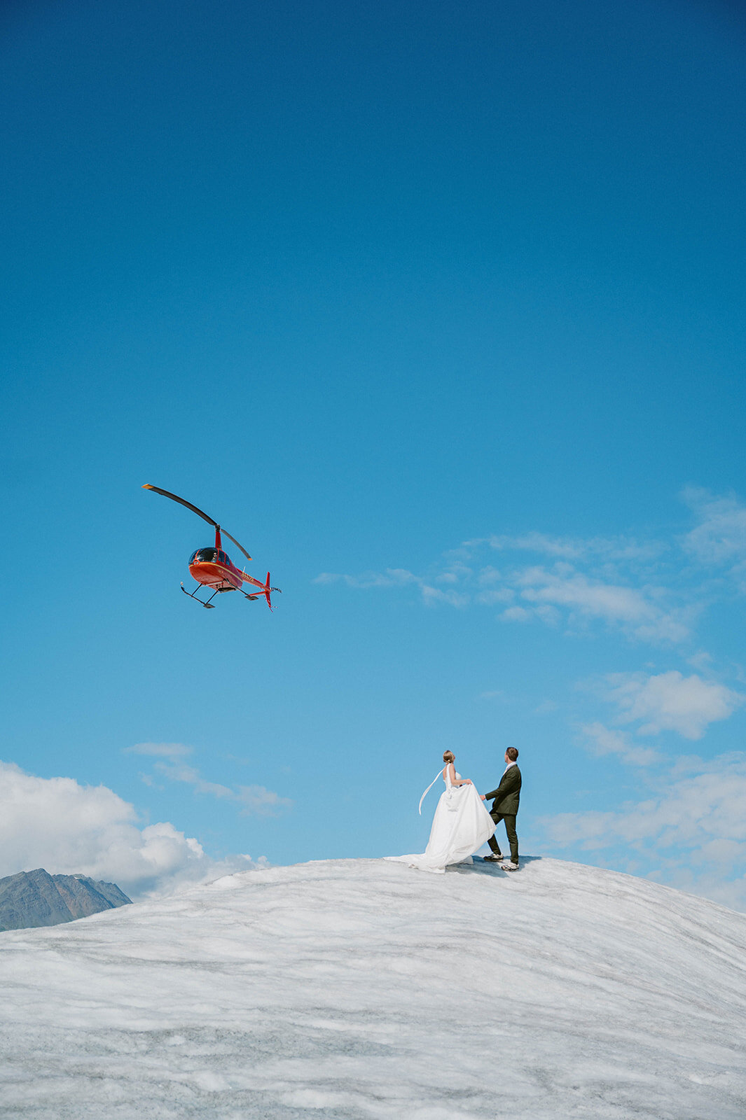 Couple watch the helicopter fly over in the air