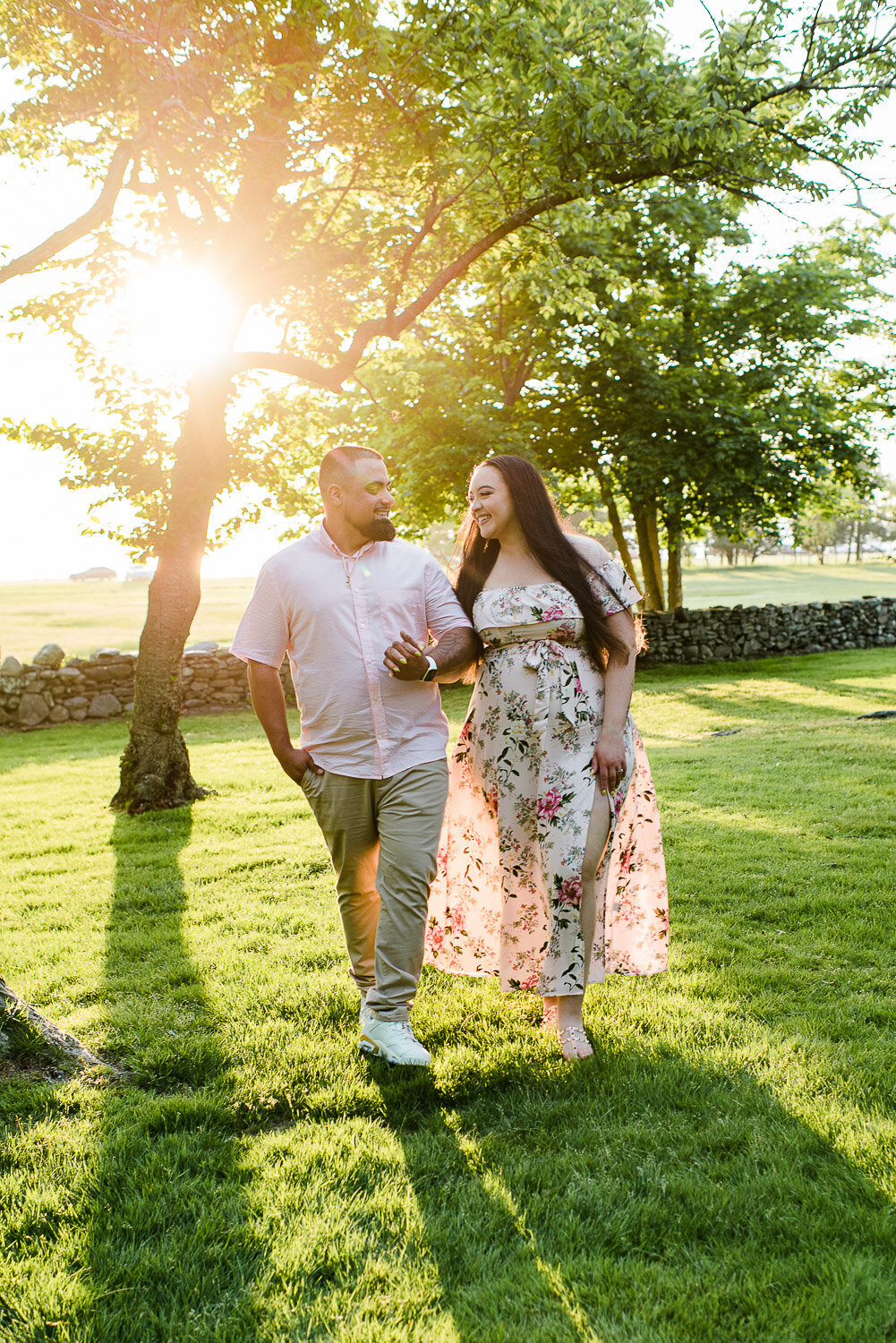 couple walking looking at each other holding hands in sunlight