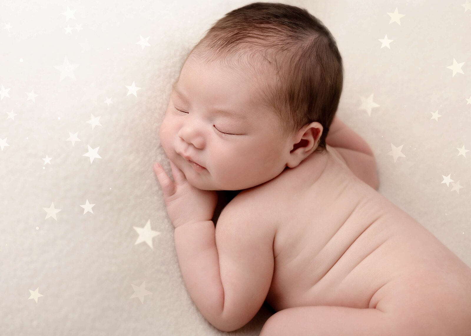 Baby girl posed with star-shaped props for a themed session, Edmonton newborn photography gallery by De La Torre Photography.