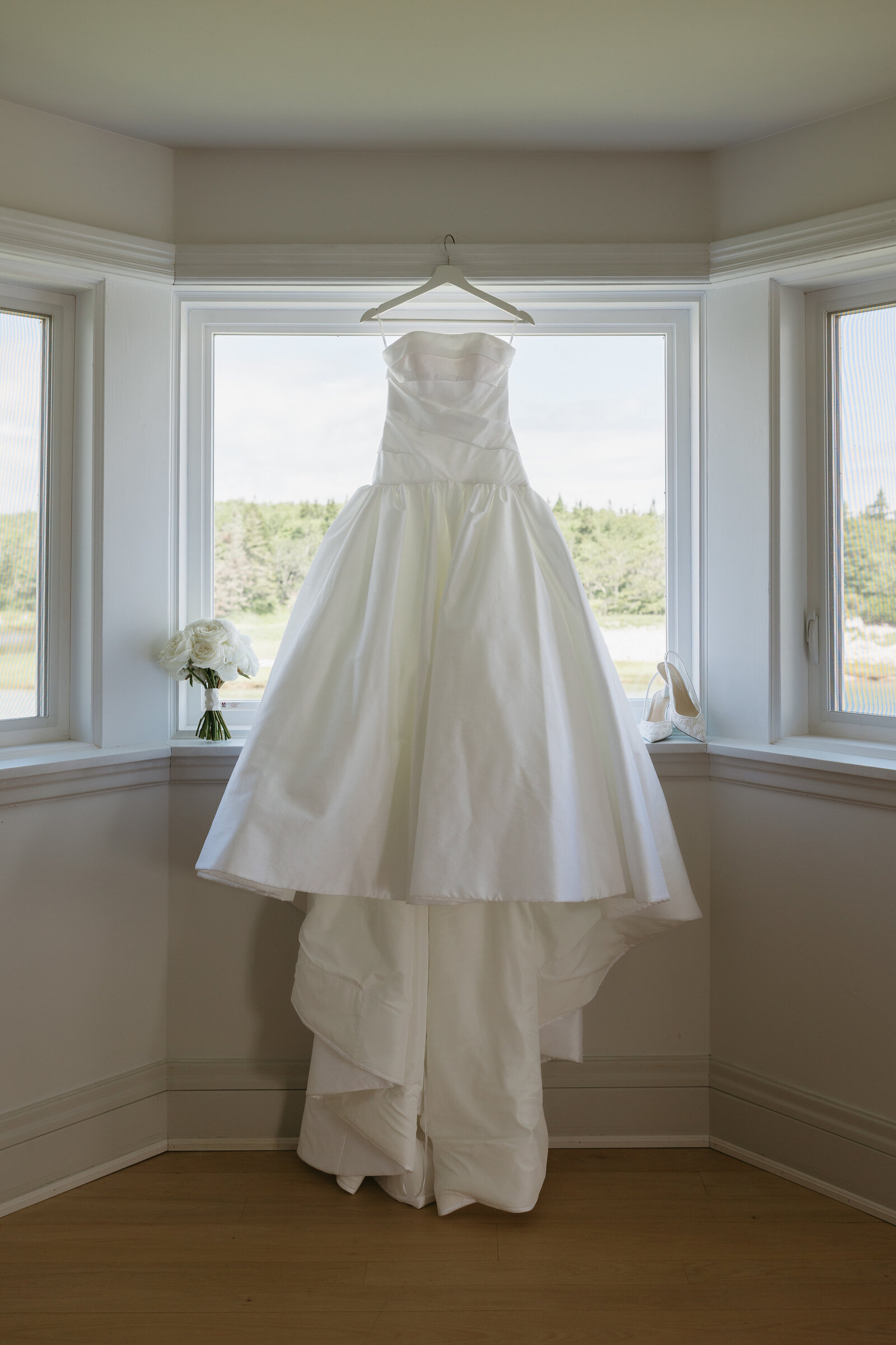 A wedding gown hangs in the window at the Bullpoint Estate in Nova Scotia.