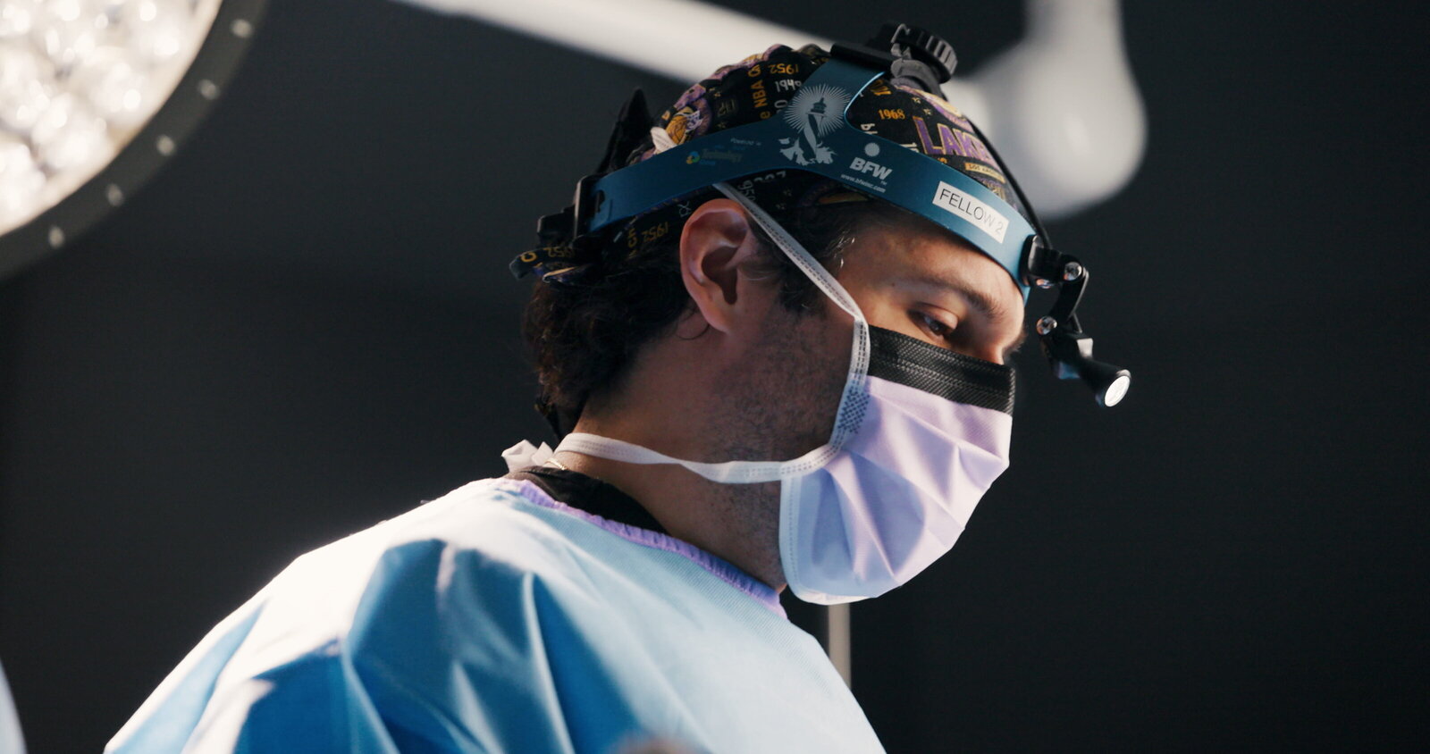 Surgeon in a surgical mask and headlight during a procedure