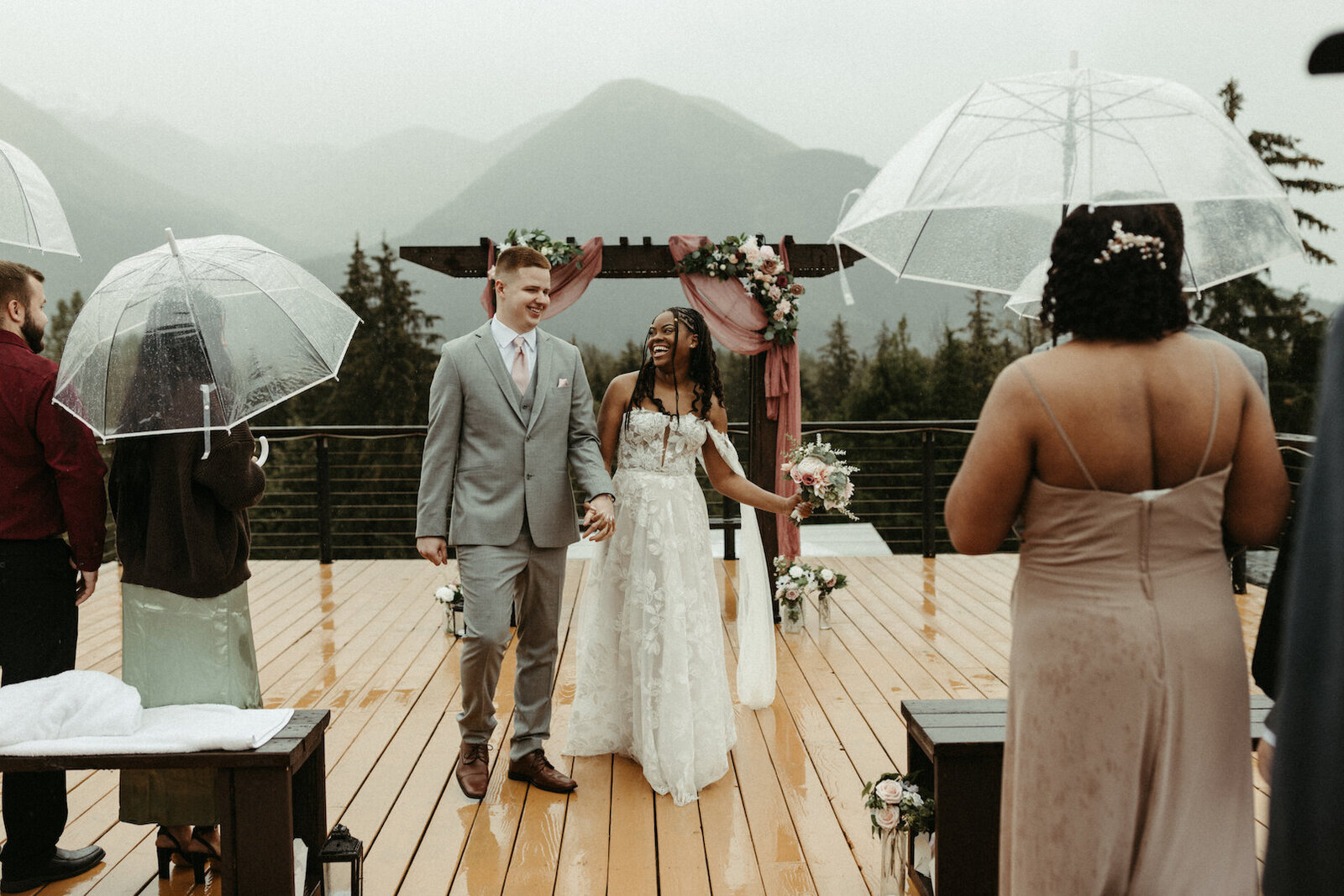 couple walking out of their ceremony in the pouring rain