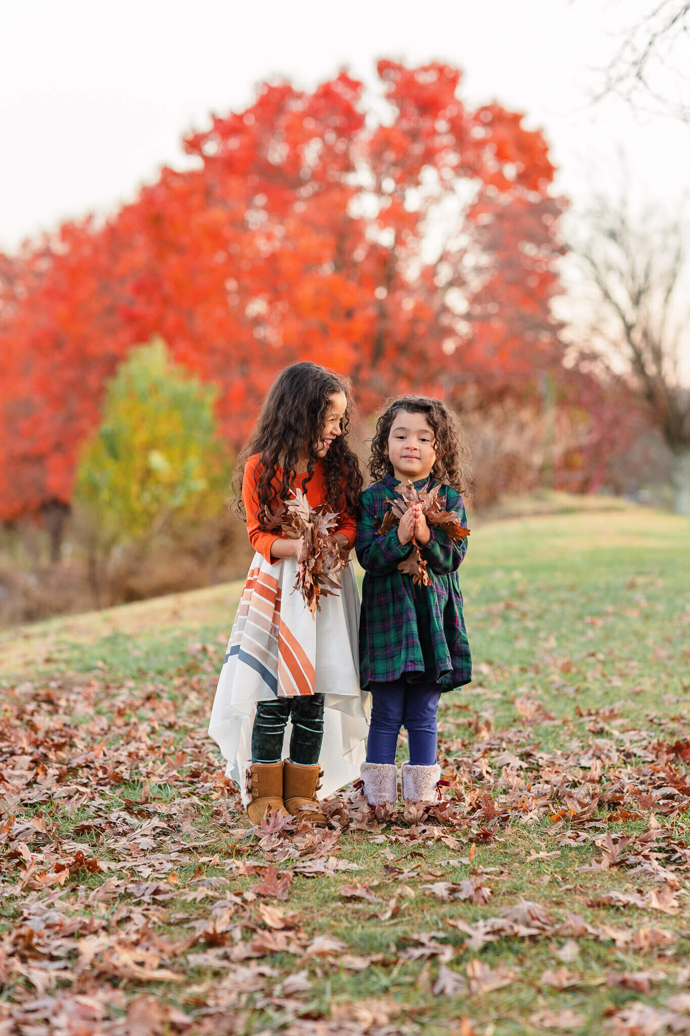 Two girls getting ready to throw leaves