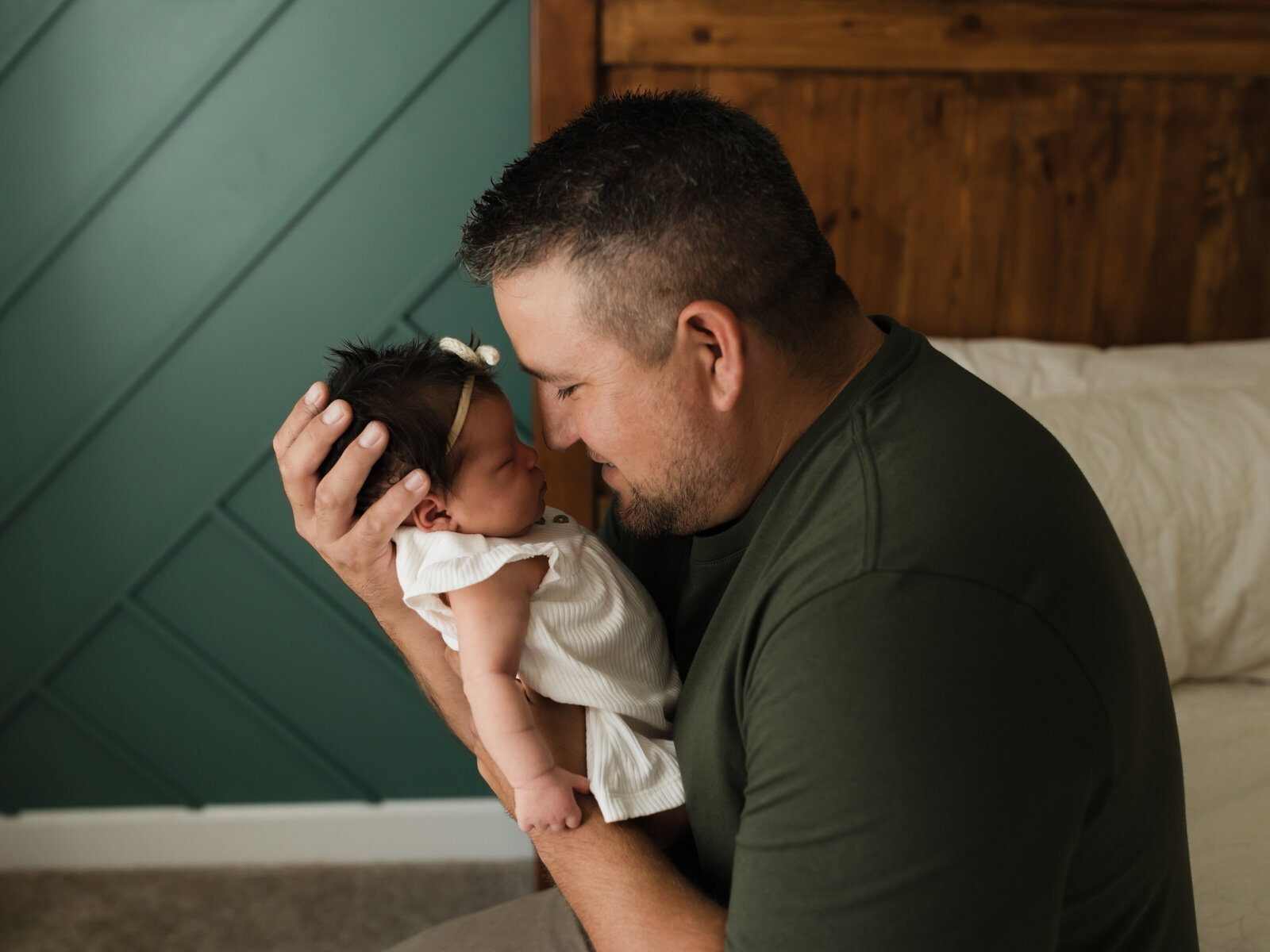 dad holding newborn baby girl for in home lifestyle session cleveland newborn photographer