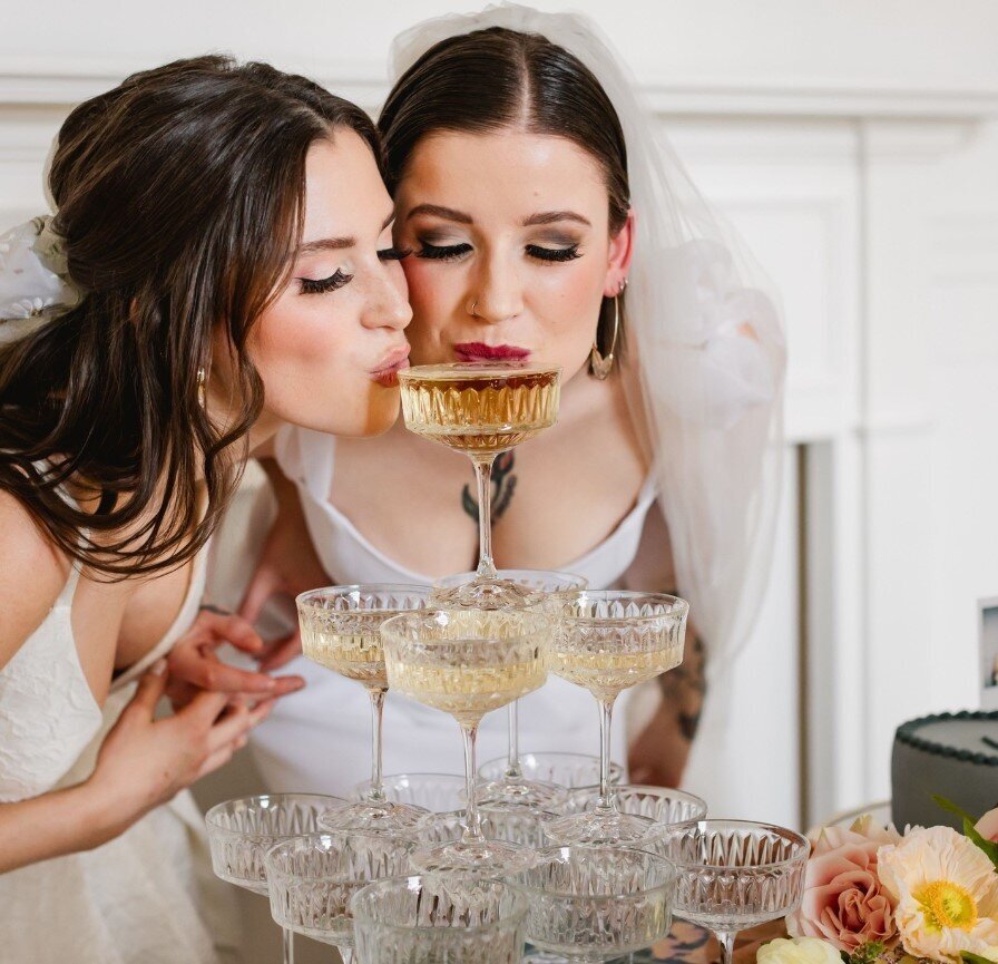 two brides sipping champagne