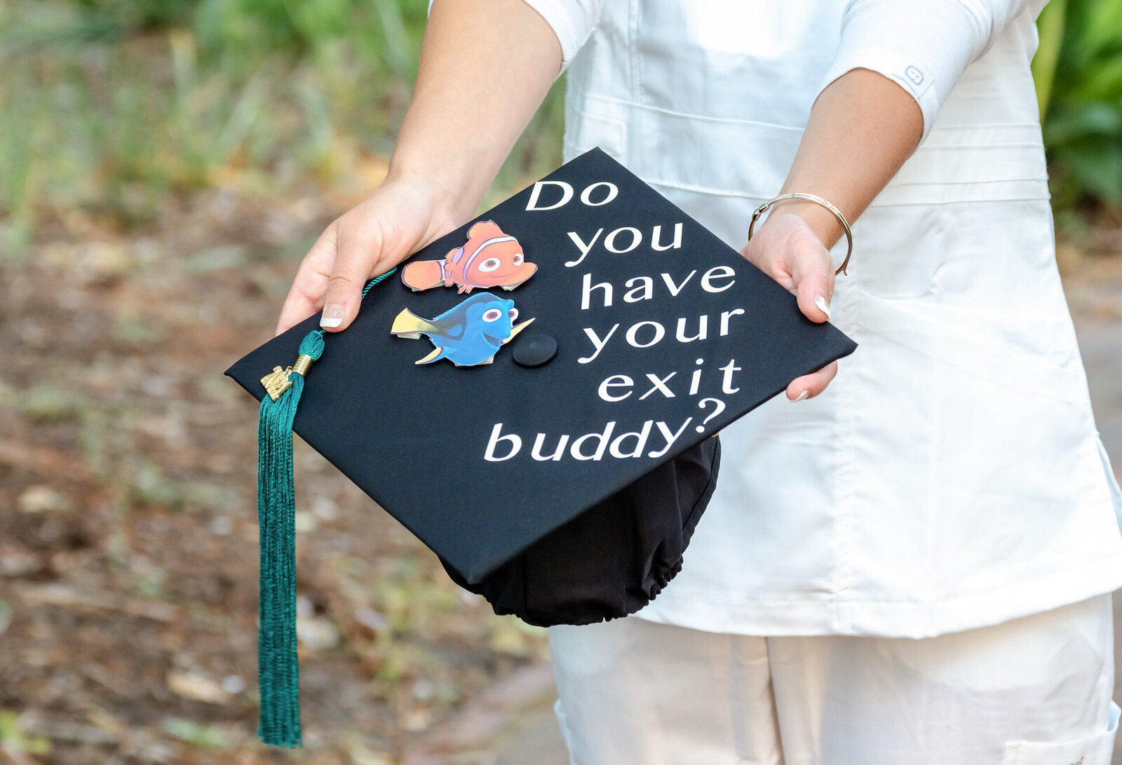 A close-up of a decorated UNCW graduation cap with a playful message, held by a nursing graduate in Wilmington, North Carolina. This image captures the creative and personal elements of graduation photography.