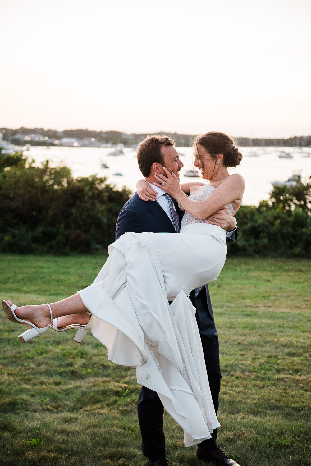 bride in grooms arms at sunset looking at each other