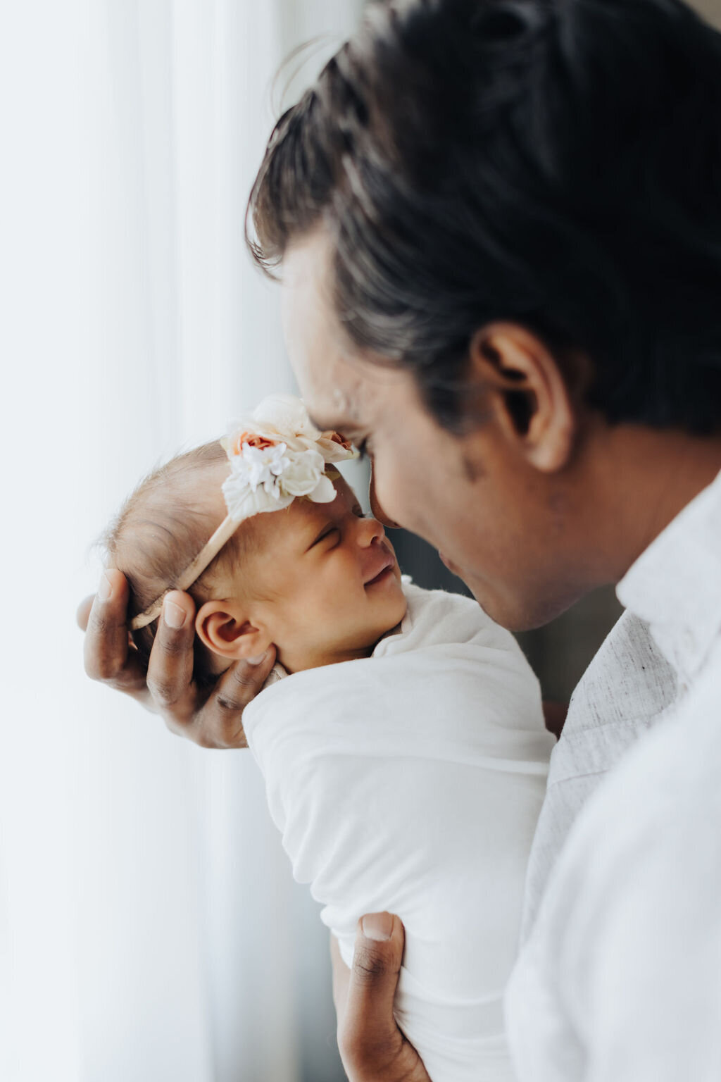 New dad kissing newborn baby