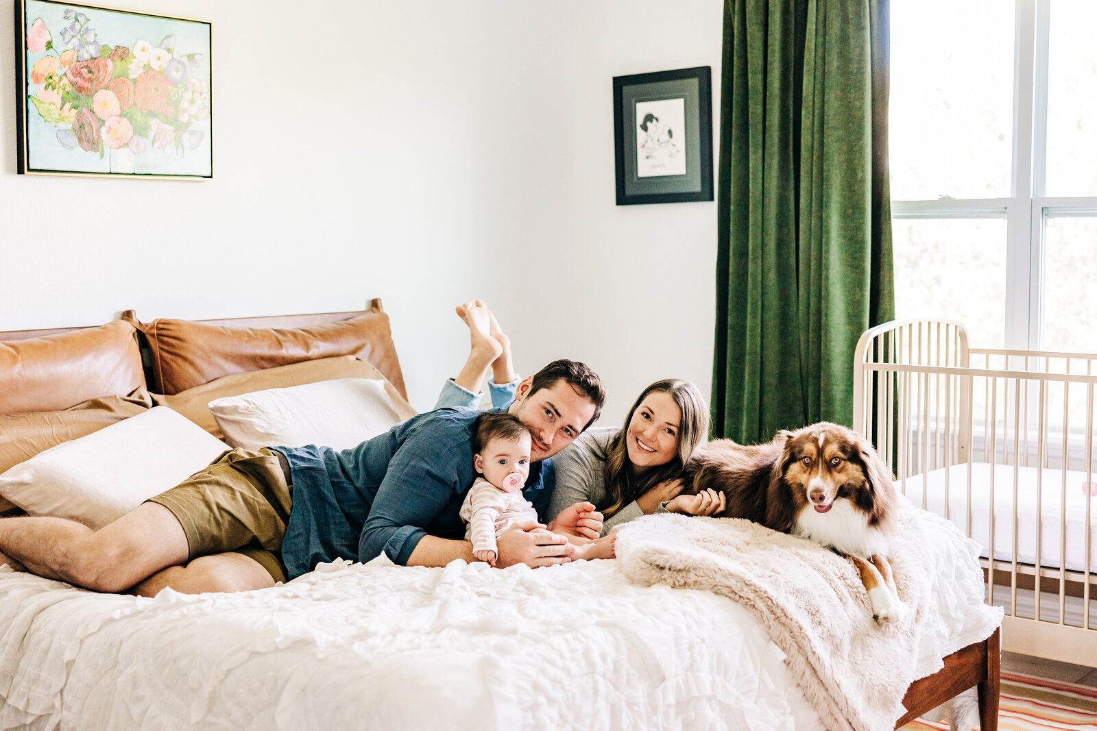 Photographer alison amick captures family and dog on the bed in a bright airy way.