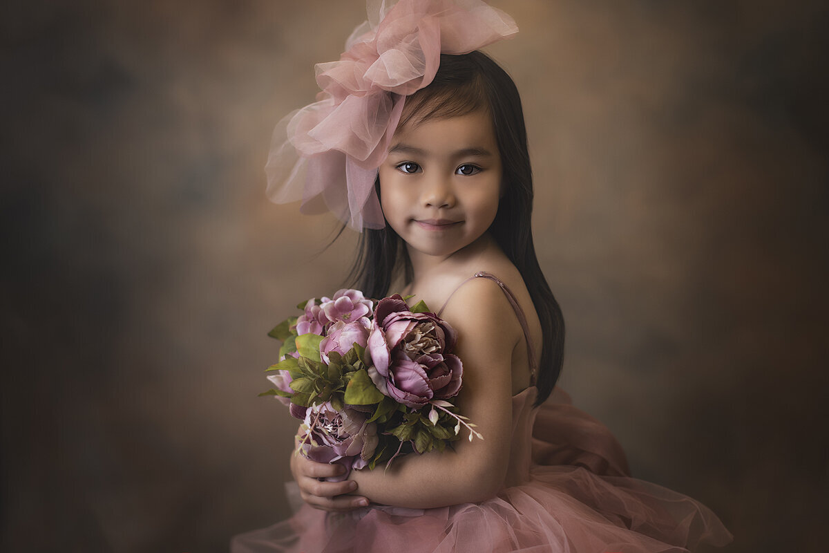 Child holding flowers in beautiful gown