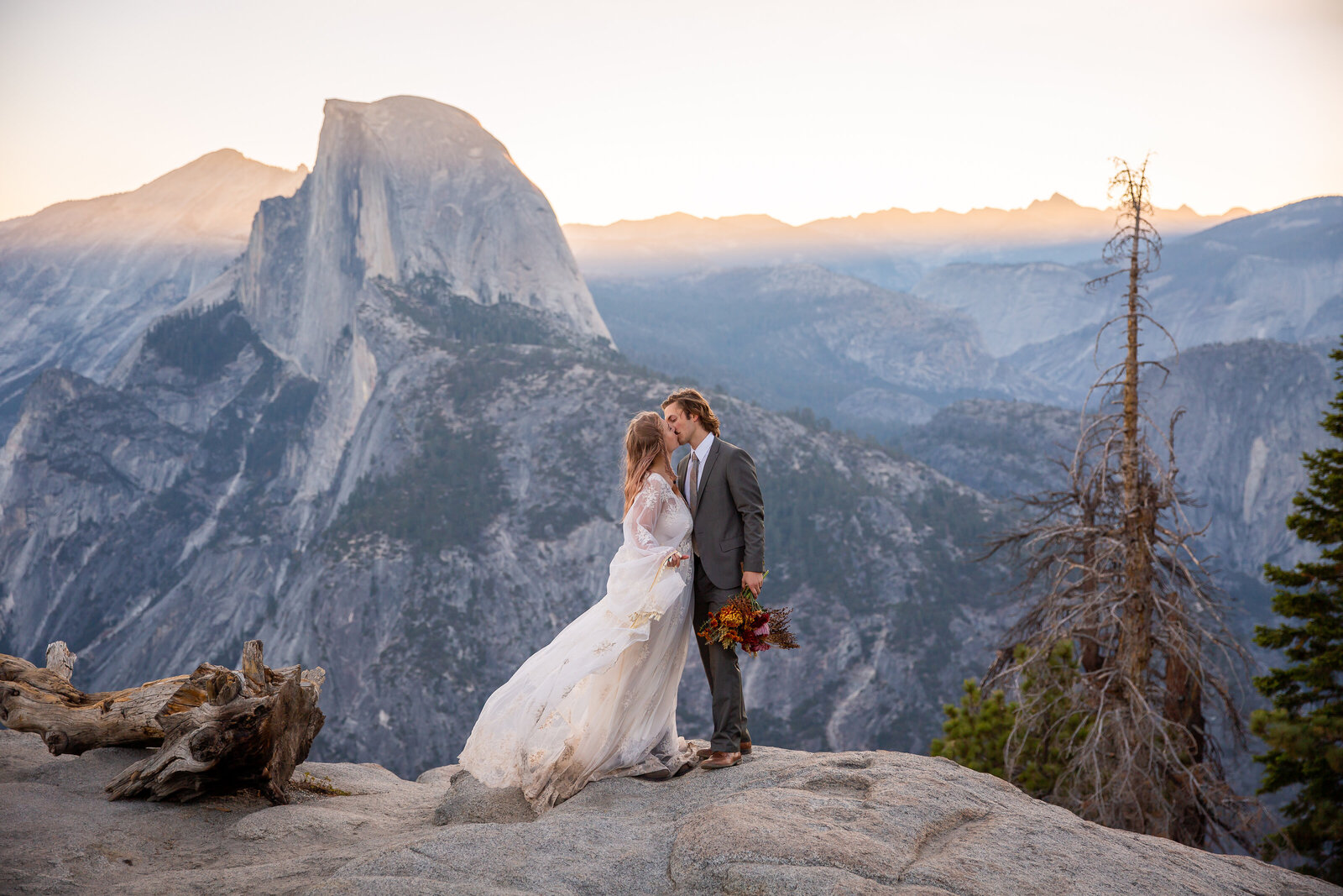 A couple kisses at sunrise at Glacier Point  during their elopement.