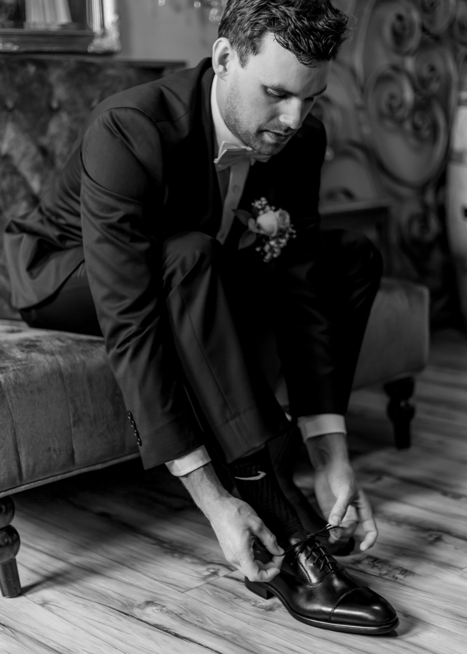 Groom putting his shoes on at the Troutdale House