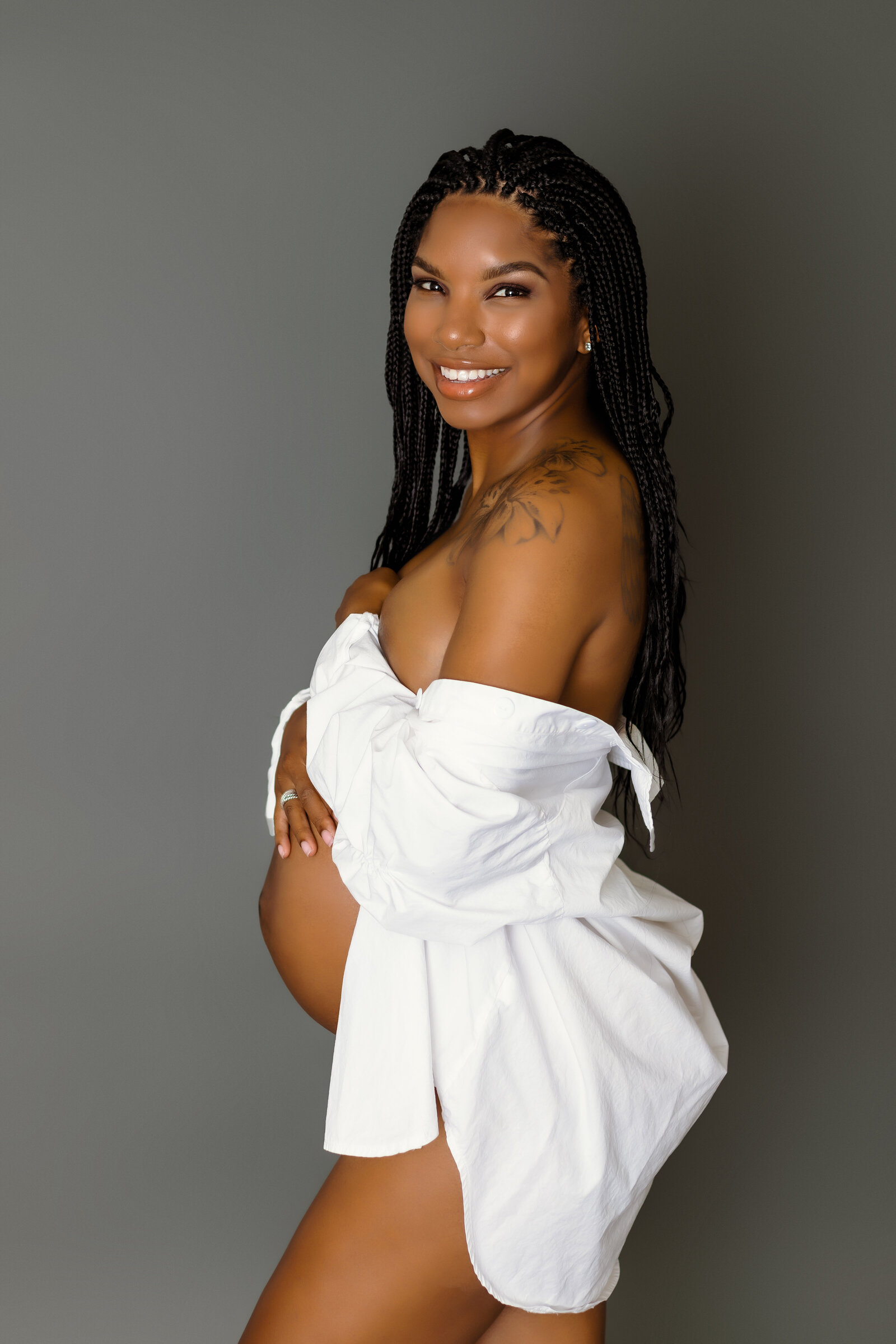Maternity Photographer, an expectant mother-to-be wears a robe with her belly exposed