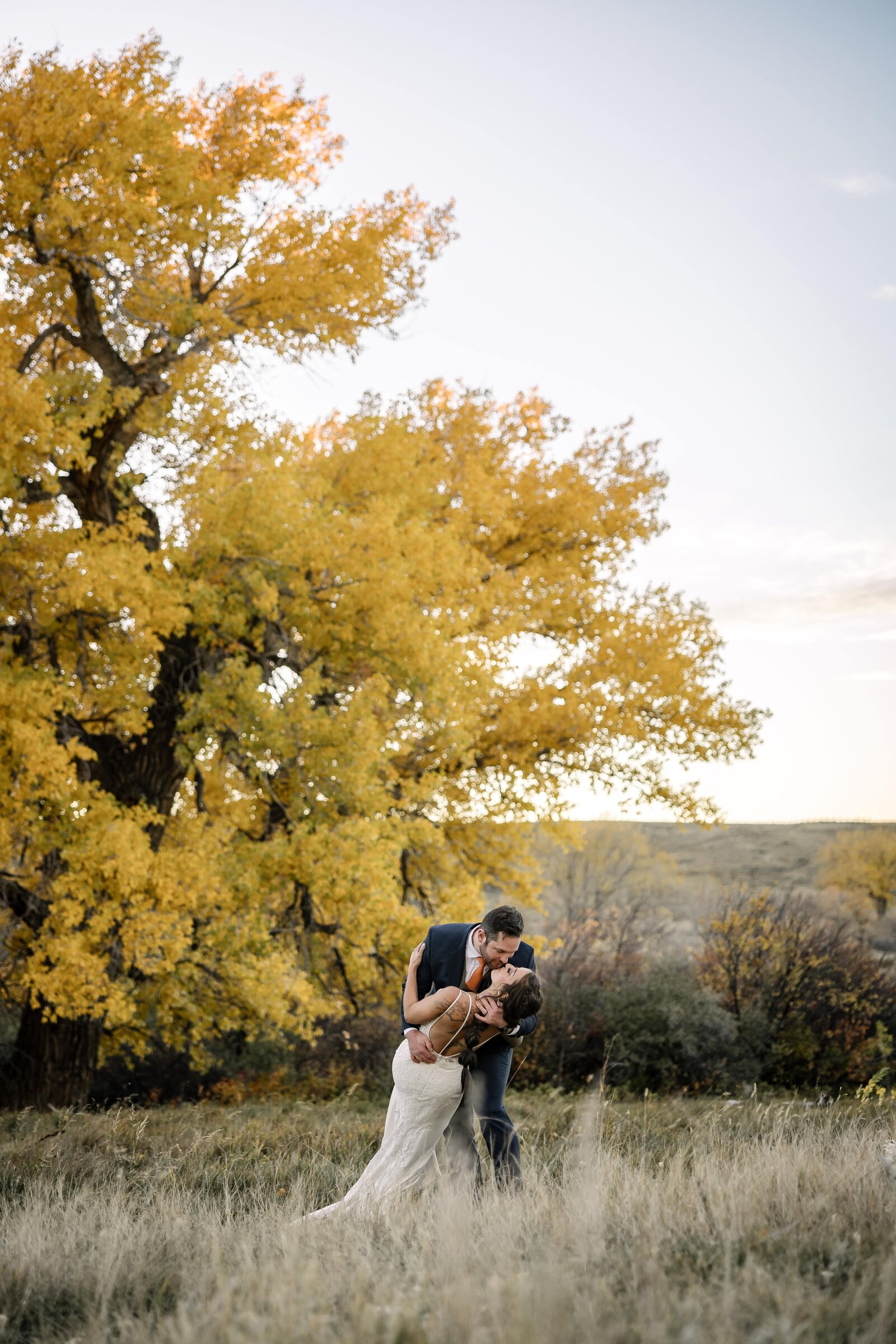 bride and groom dance under fall cottonwood tree