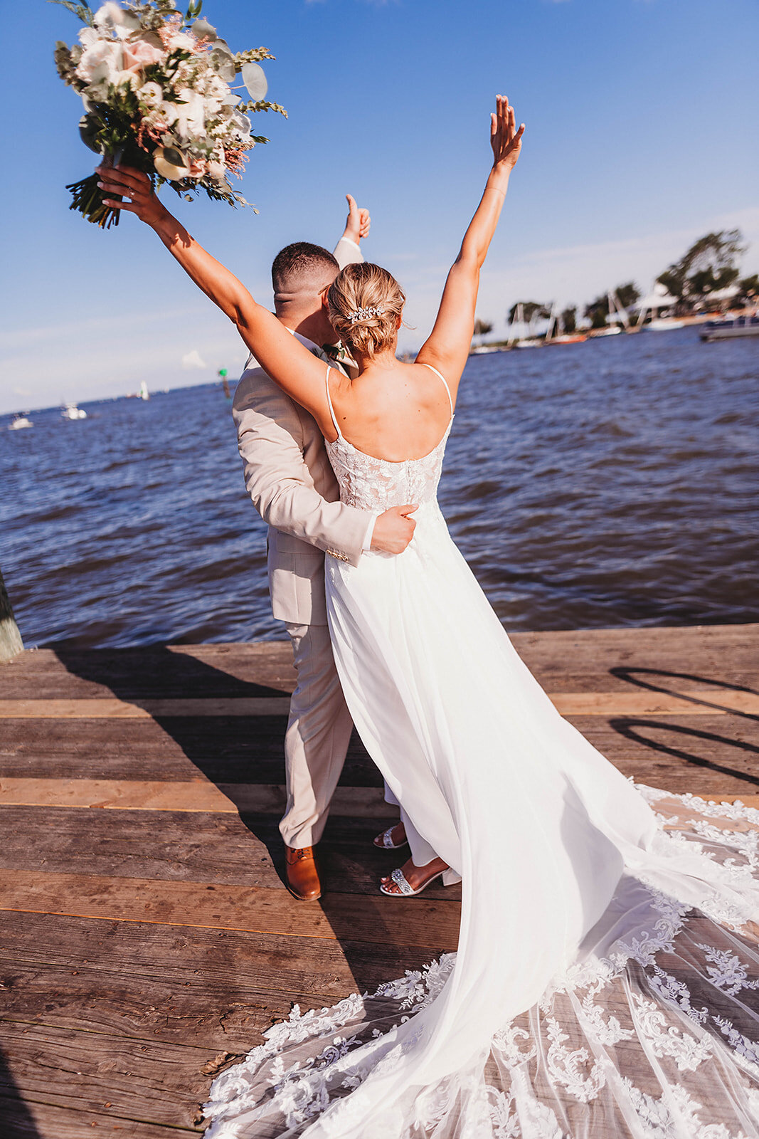 bride and groom waving to onlookers as they are cheered for getting married