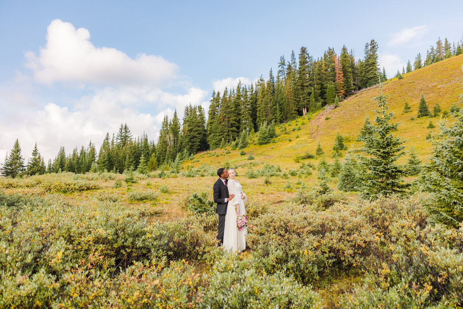 Bride and groom posing together at their elopement in Berthoud Pass, Colorado.