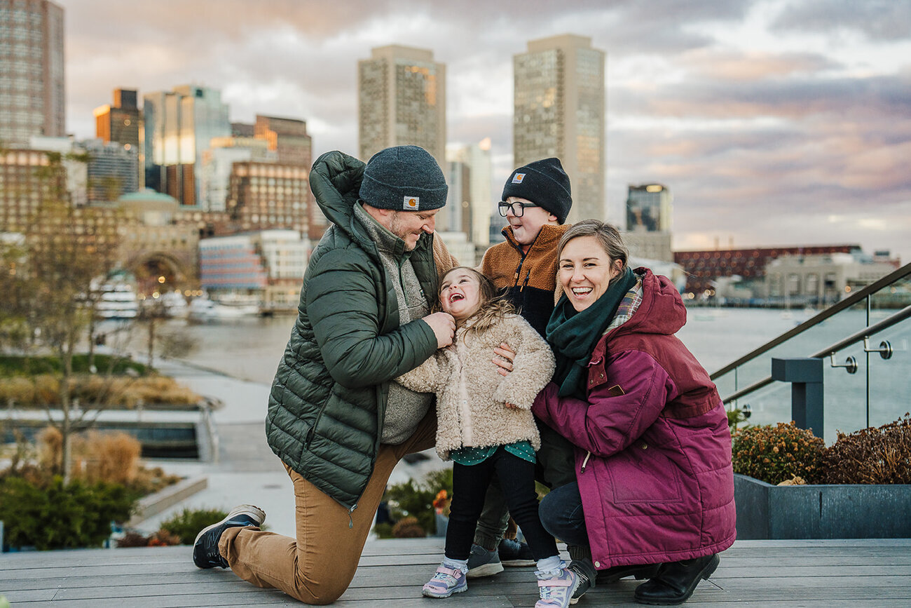 family laughs together overlooking boston seaport
