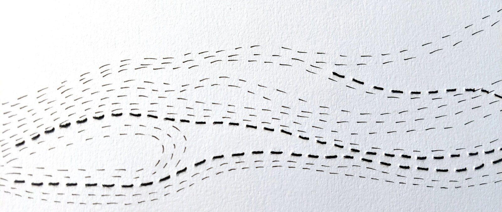 Curving lines of black stitches and black pen marks on white paper. Art by Hannah de Keijzer.