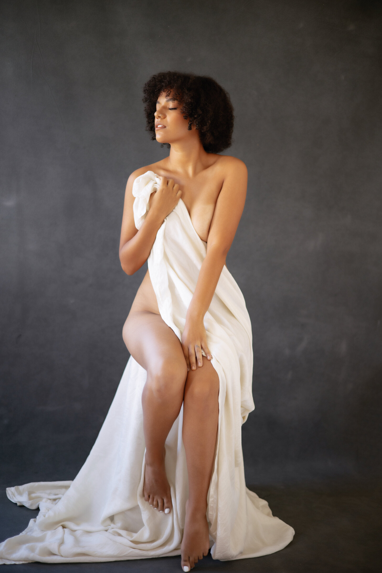 Black woman wrapped in white sheet