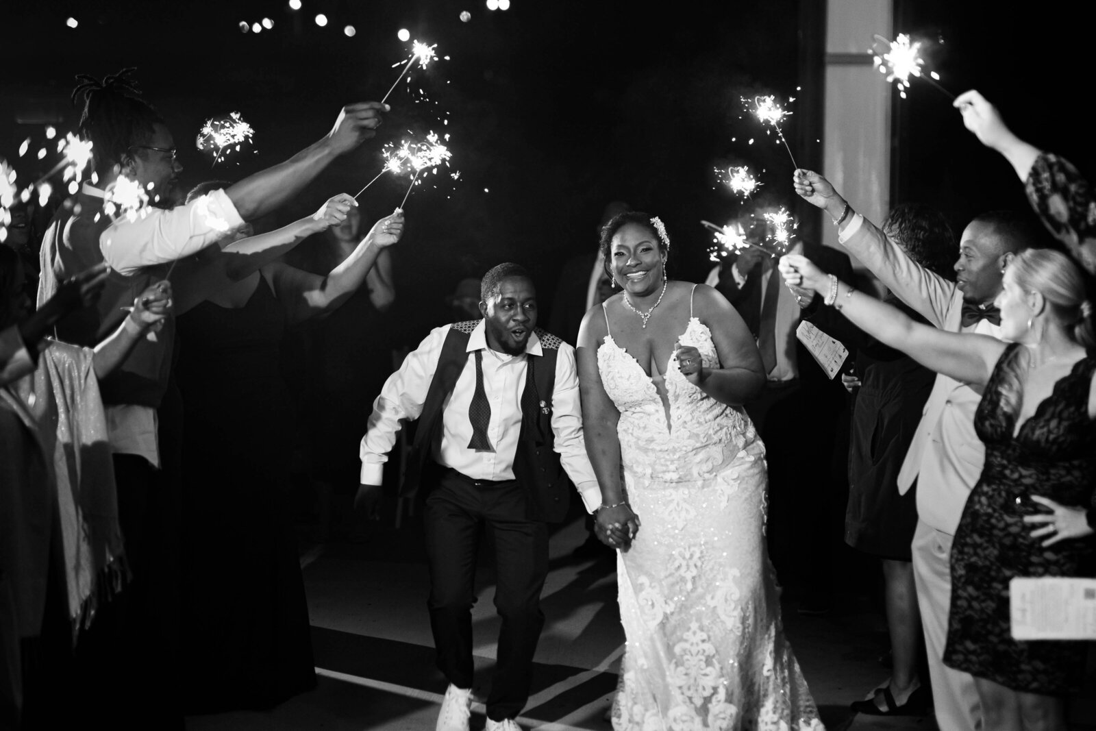 Black married couple running under sparklers