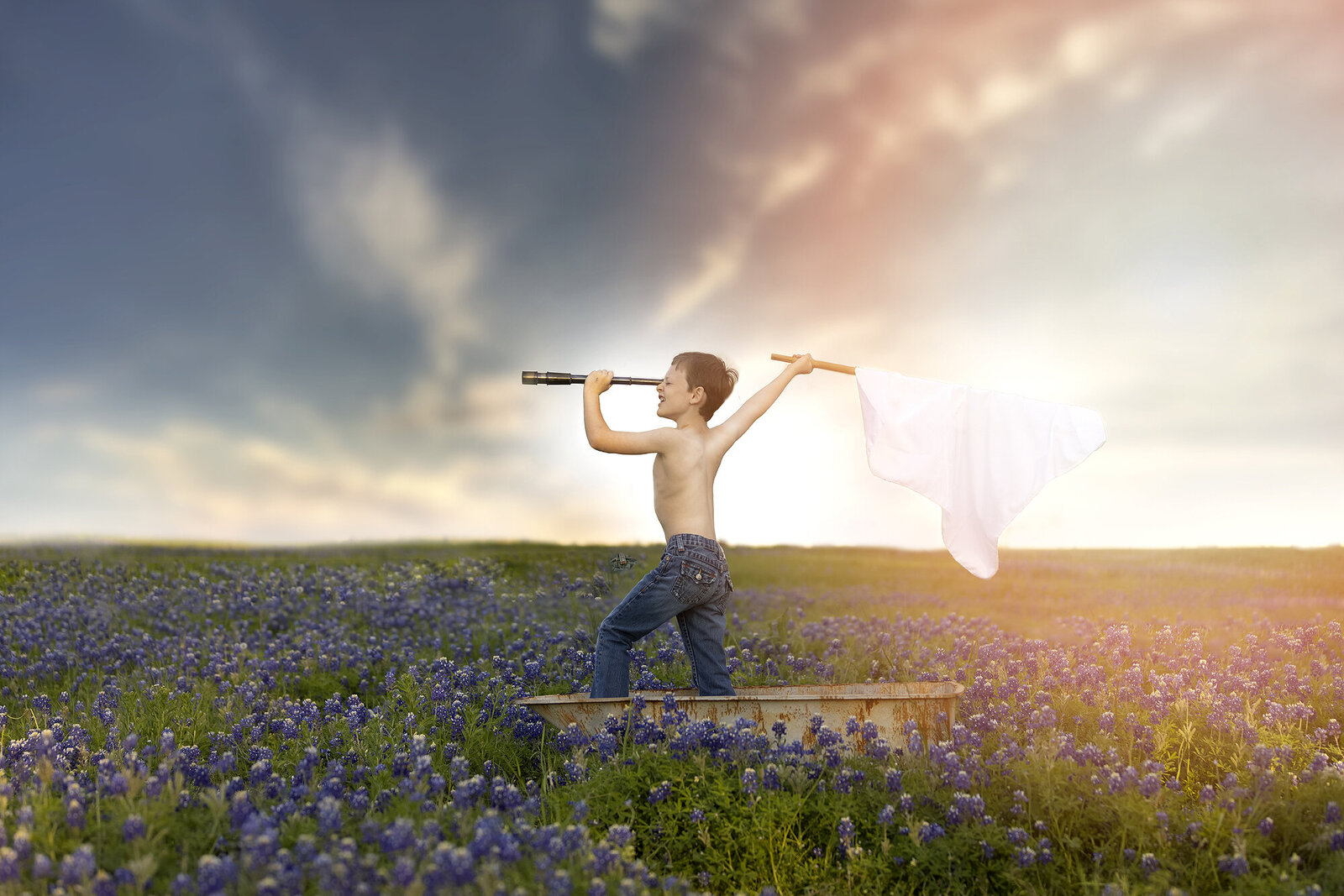 Boy in a field of bluebonnets pretending h'es a ship captain