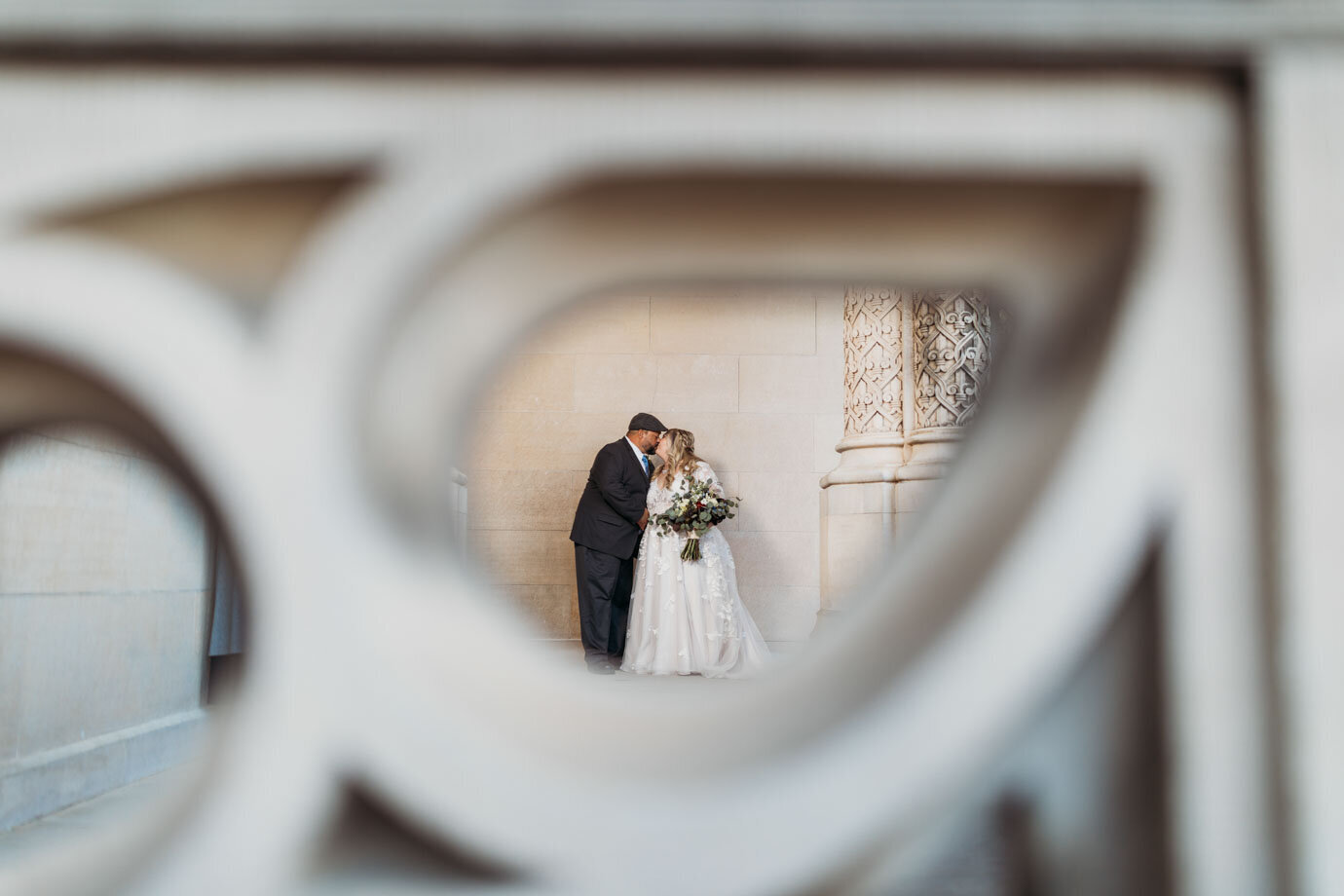 Couple kiss in this creative foreground shot at the historic Biltmore Asheville TN