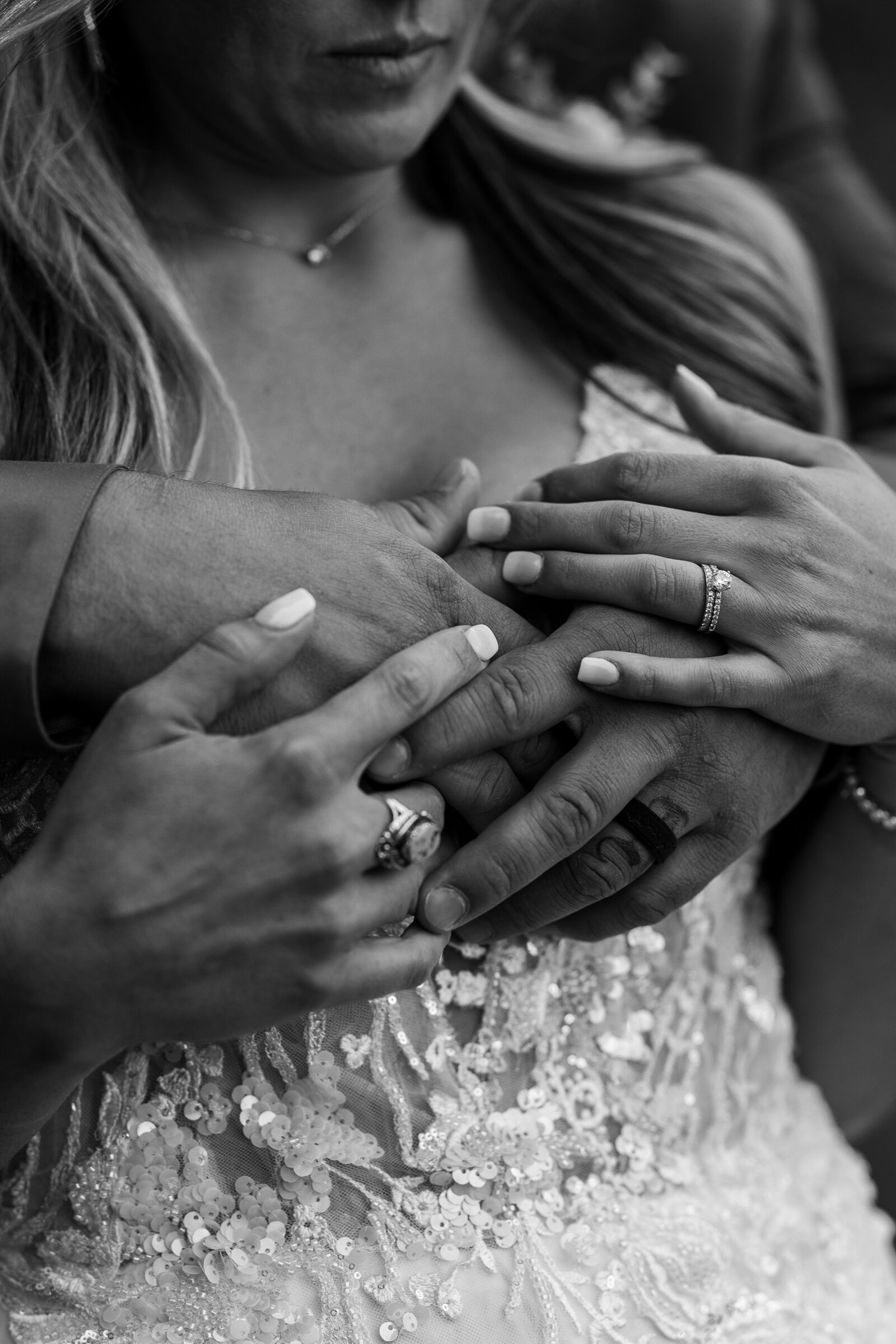 Bride places her hand over the grooms hands in this romantic black and white image