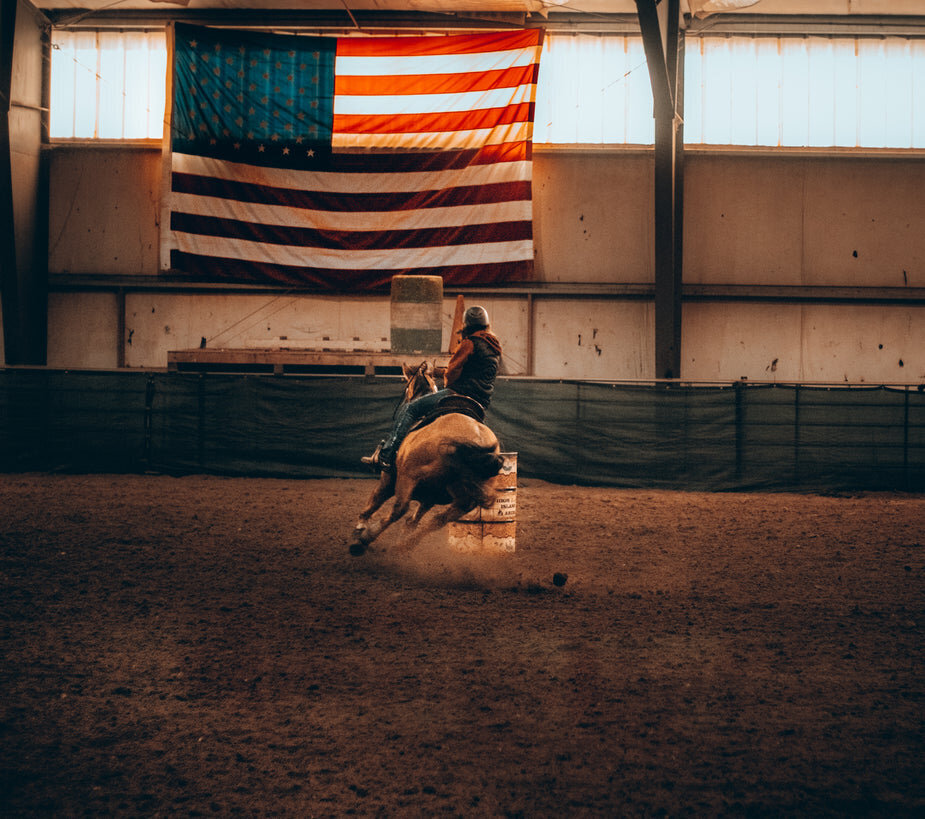 person-rides-a-horse-around-a-sharp-turn-indoors