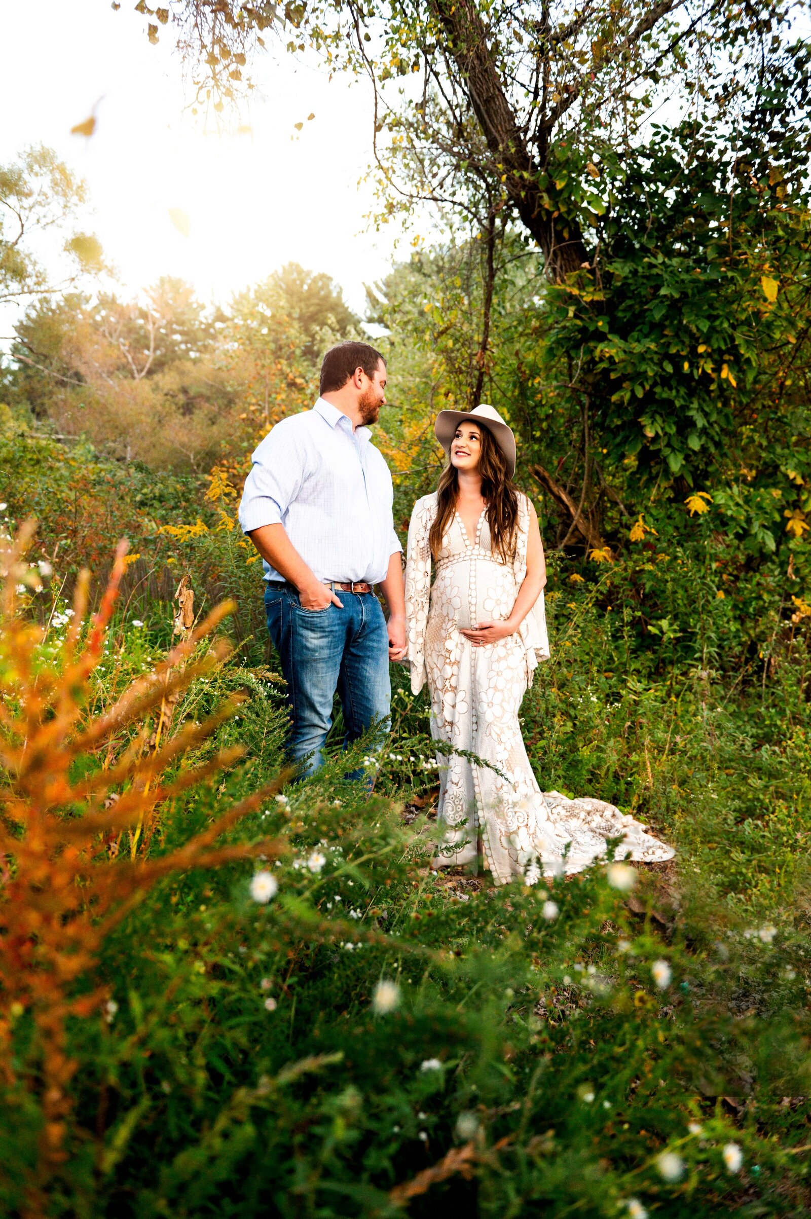 Wife looking back at her husband at a maternity photoshoot