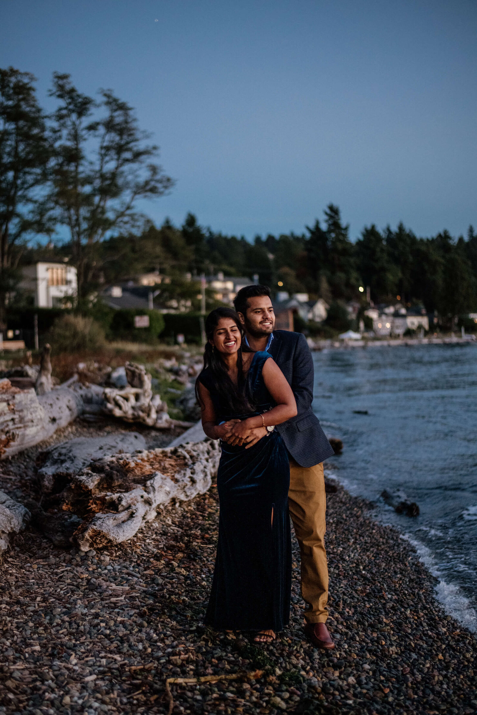 Couple holding each other near the water.