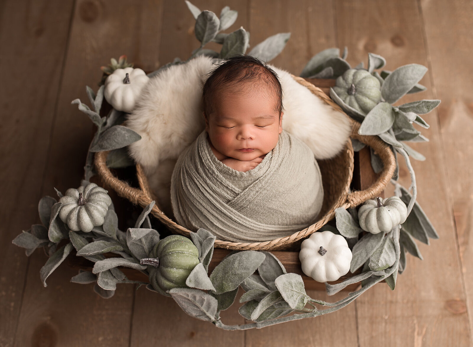 fall baby surrounded by pumpkins in sage green