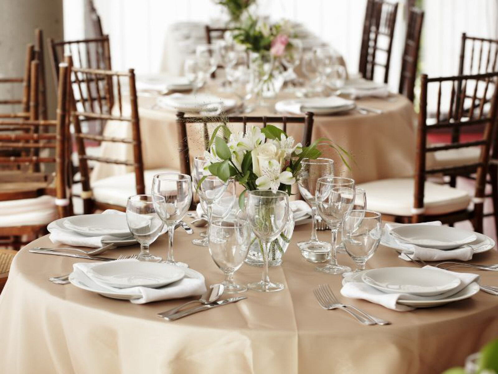 Wedding reception round tables with dinnerwares and floral centerpieces