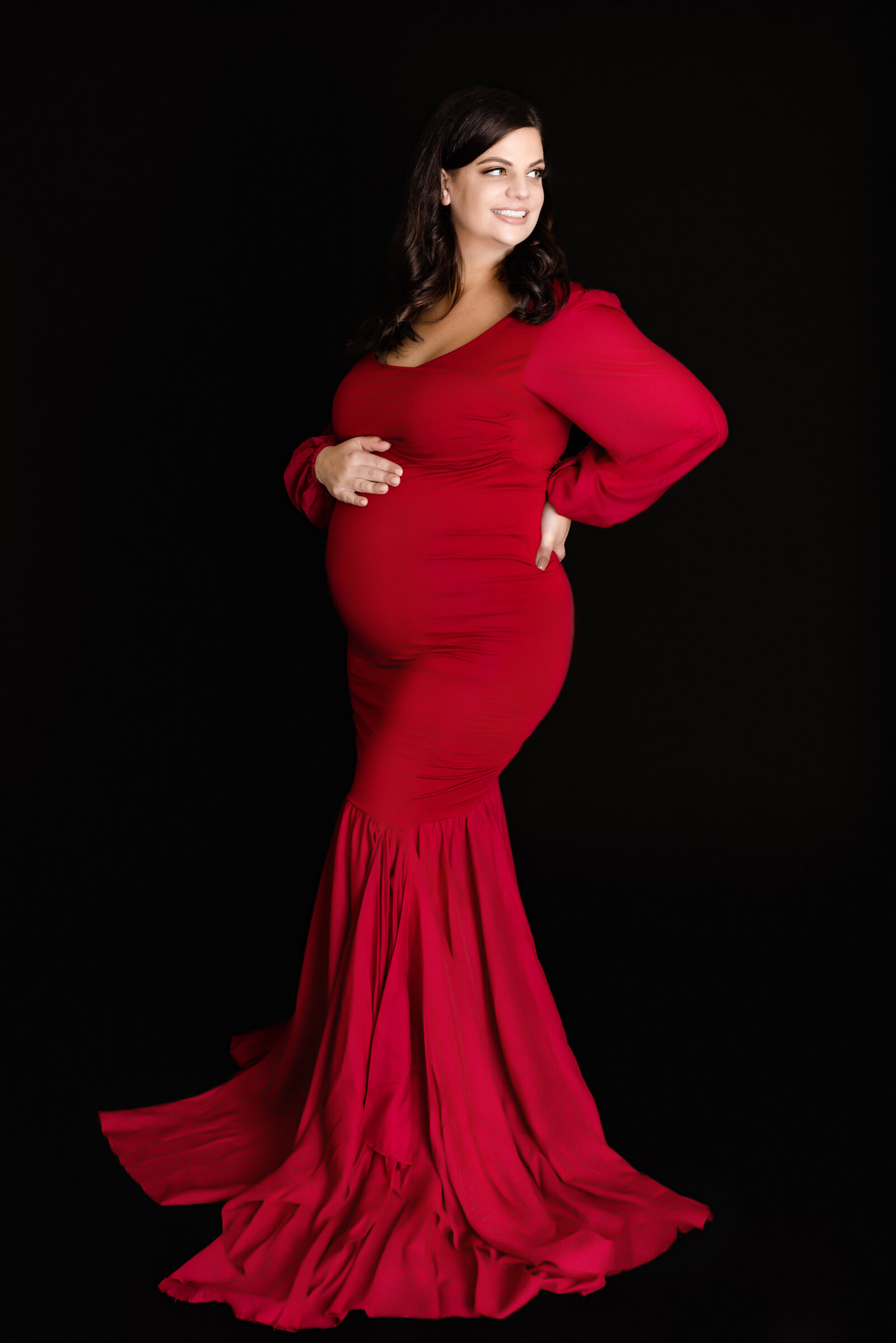 Maternity Photographer, a happy mother-to-be wears a red maternity photographer