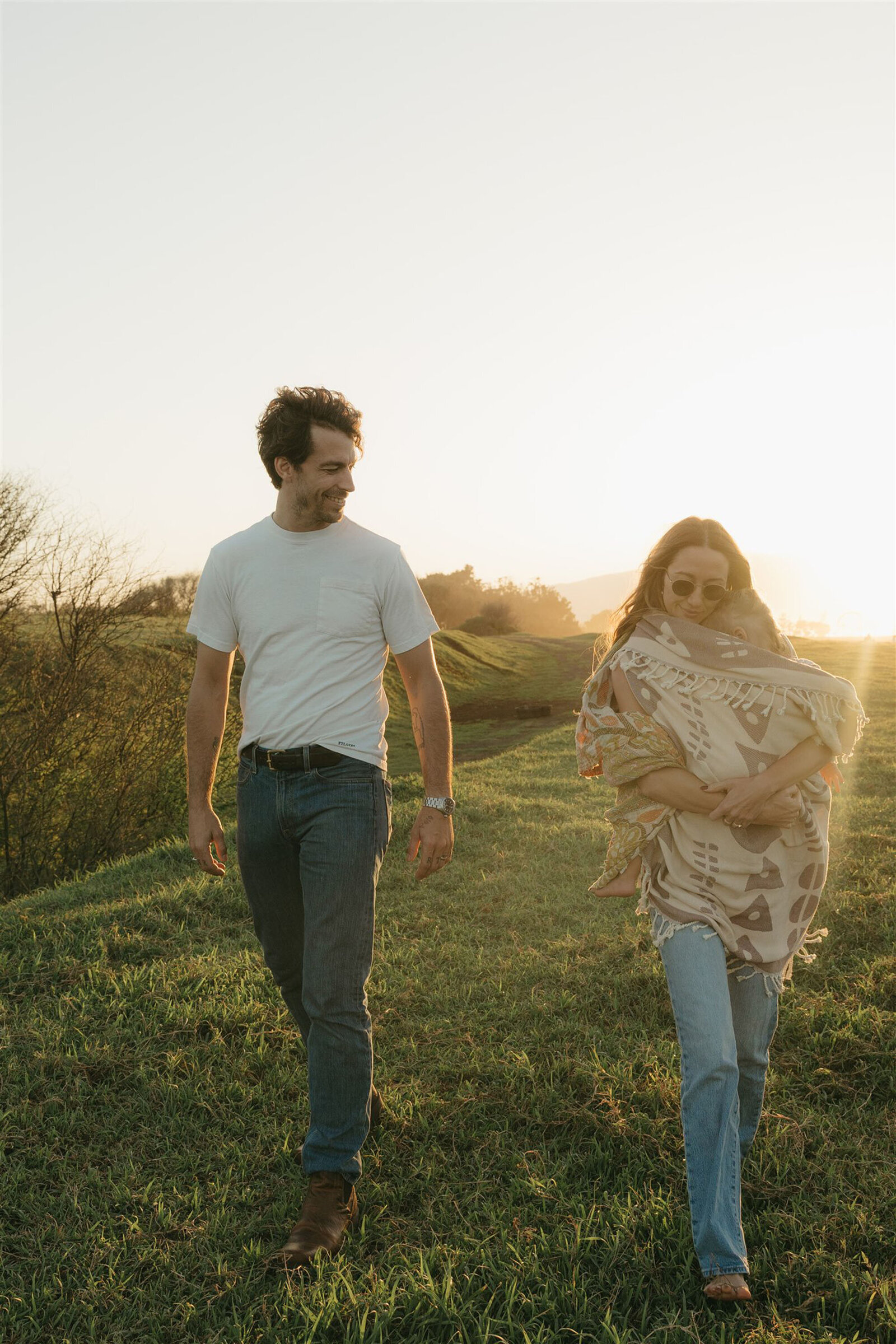Styled Maui family photography session on a cliffside, capturing play and connection in denim and neutral tones.