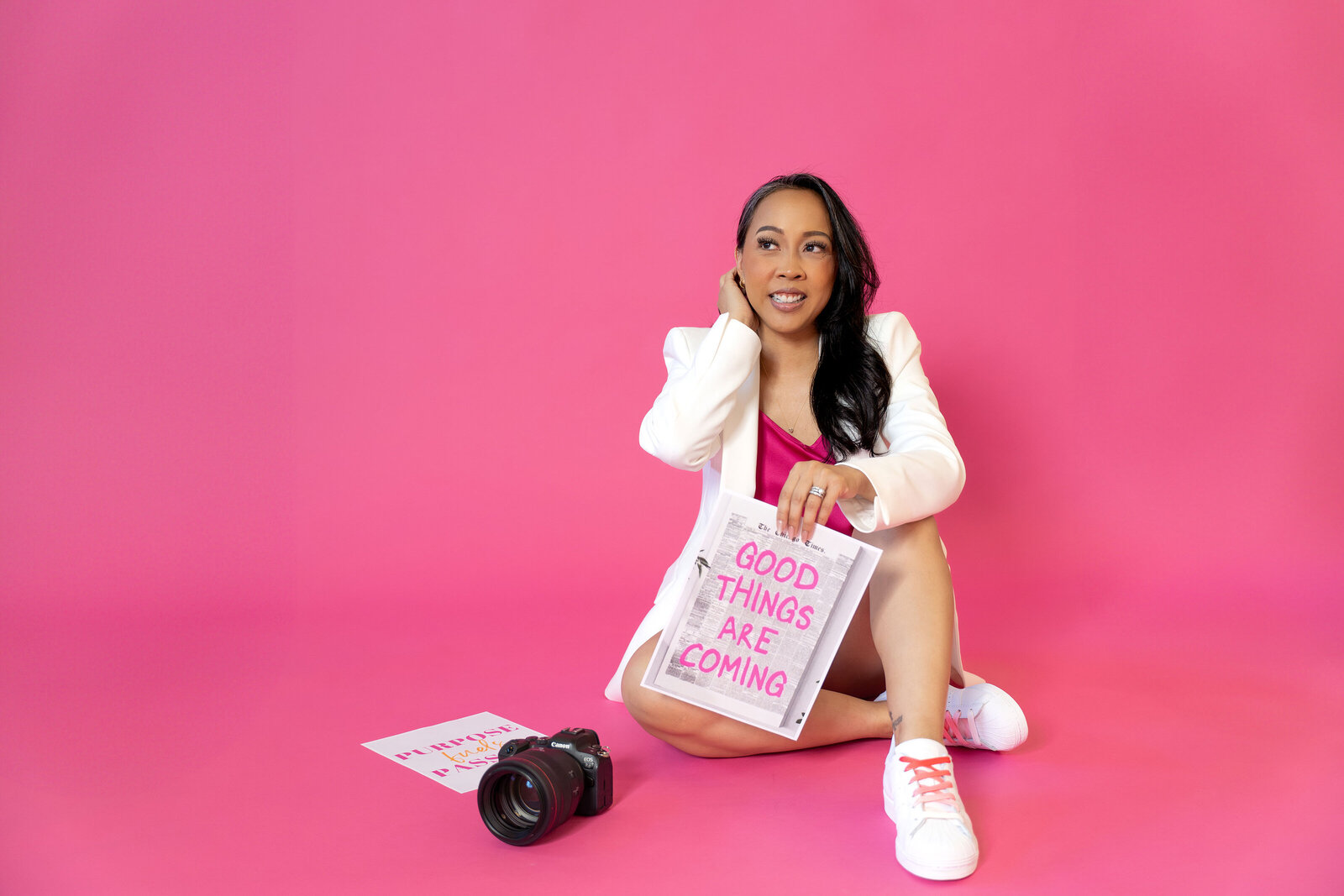 Sophie K. Hunter, brand photographer for entrepreneurs in Dallas, poses in white outfit with camera in studio