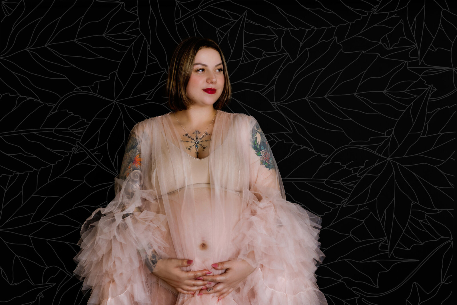 Maternity Photographer, a pregnant mother holds her belly in a pregnancy gown