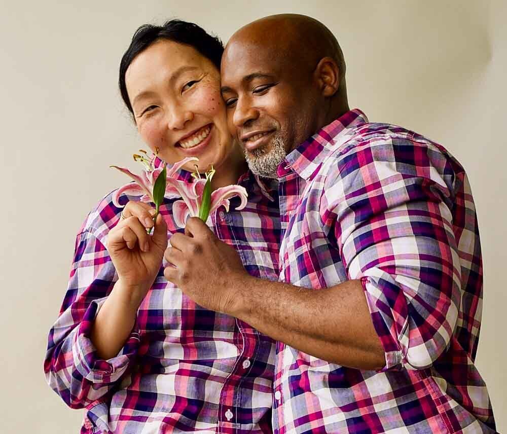 Couple smiling and holding flowers