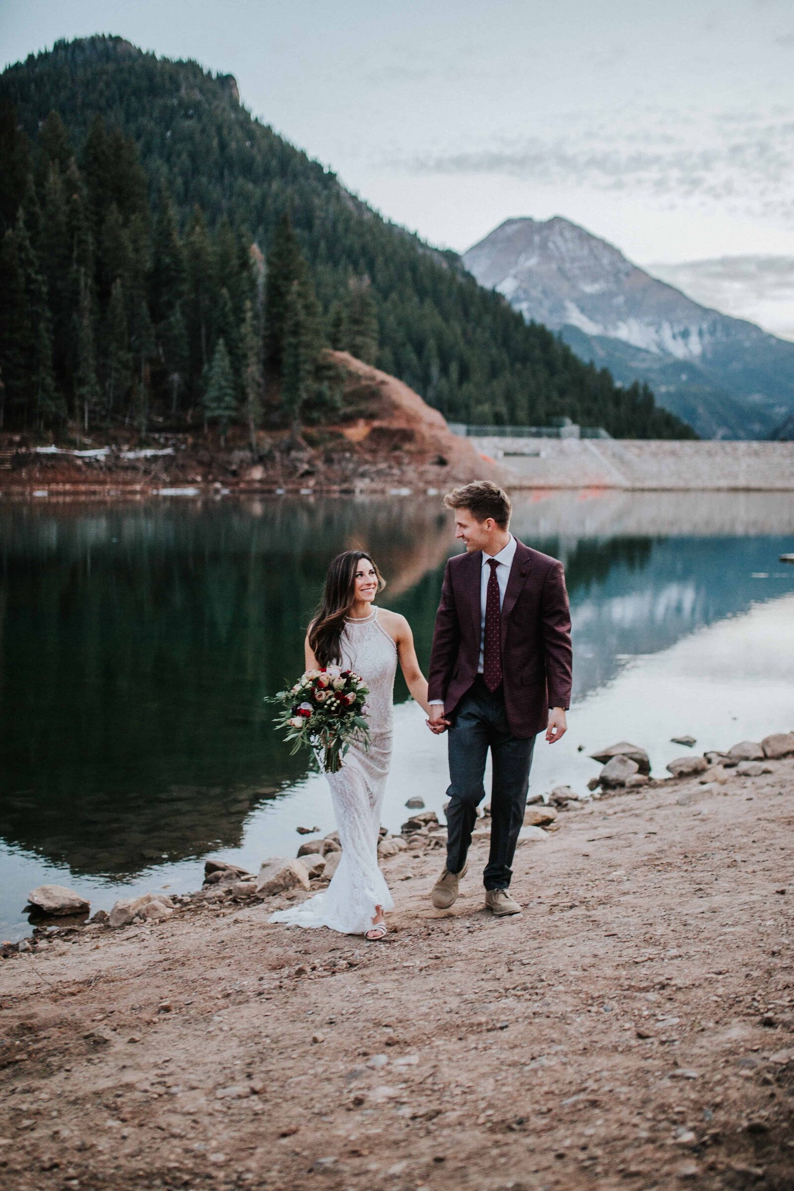 boho styled bride and groom walking near smoky mountain lake