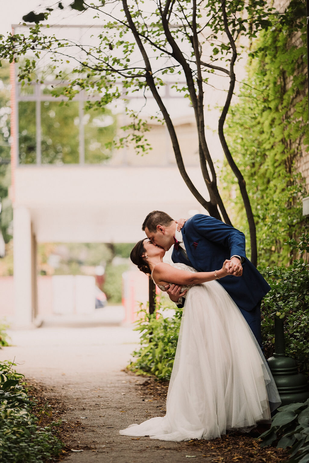 Bride and groom kissing in an alley