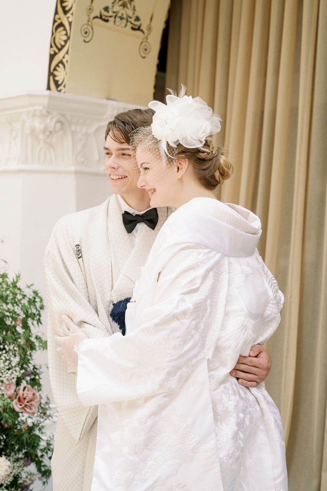 Smiling bride in traditional white shiromuku and groom in classic montsuki kimono posing together at The Ebell Club Long Beach, Los Angeles California — perfect for Japanese wedding kimono rental | 白無垢花嫁と紋付袴の新郎が笑顔で並ぶ ザ・エベルクラブ・ロングビーチ ロサンゼルス カリフォルニア 着物レンタル