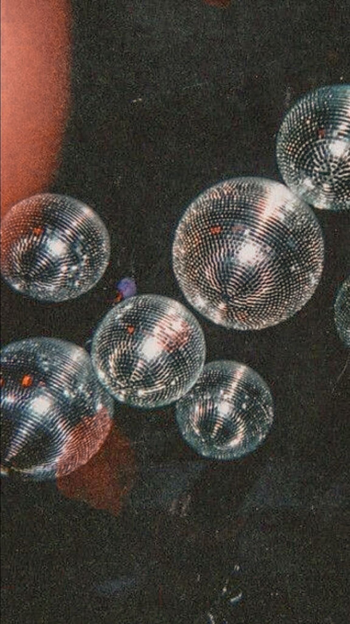 Mirrored disco balls catching light above the studio floor