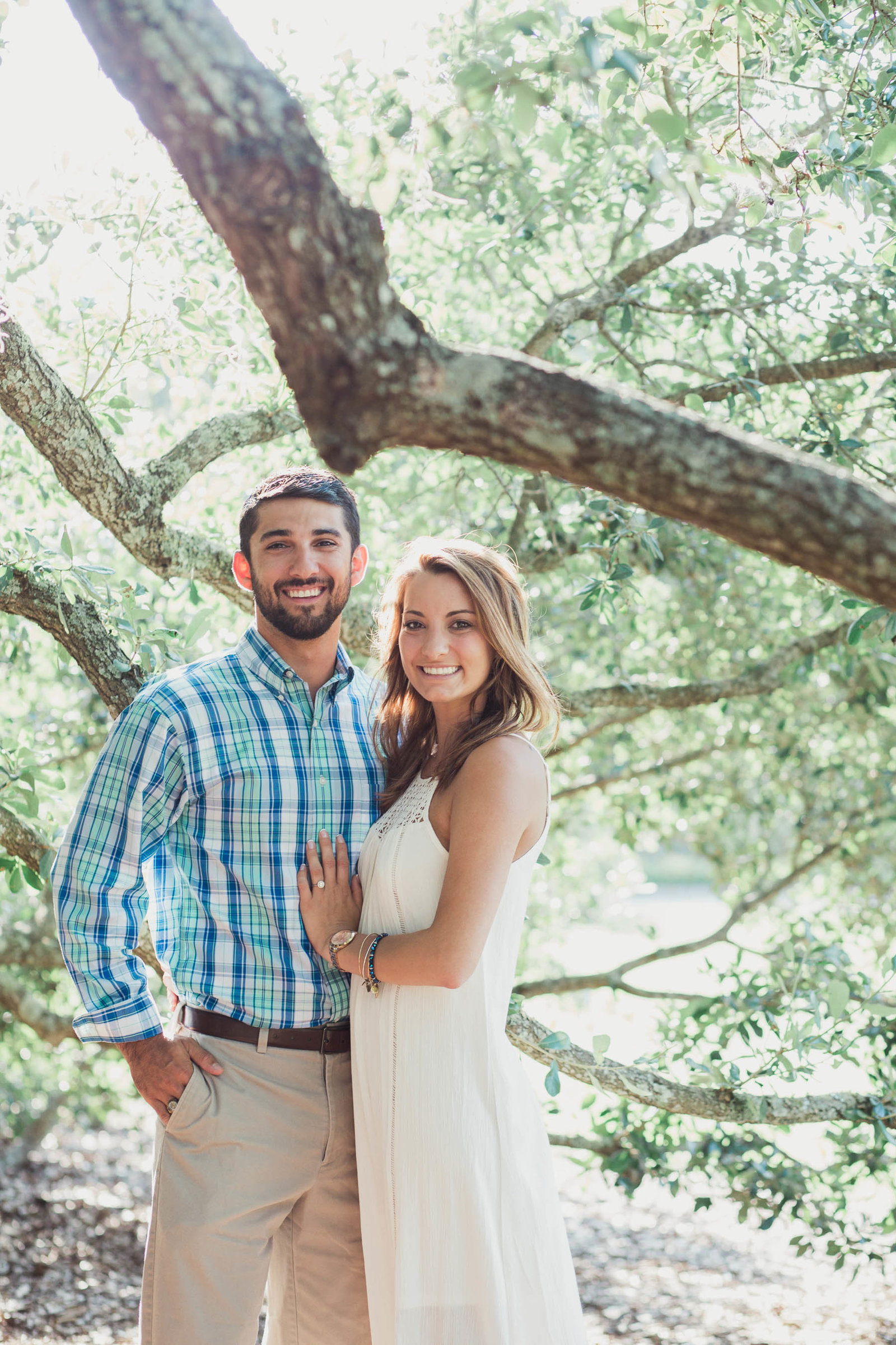 Engaged couple posing underneath oak tree, Hampton Park, Charleston, South Carolina