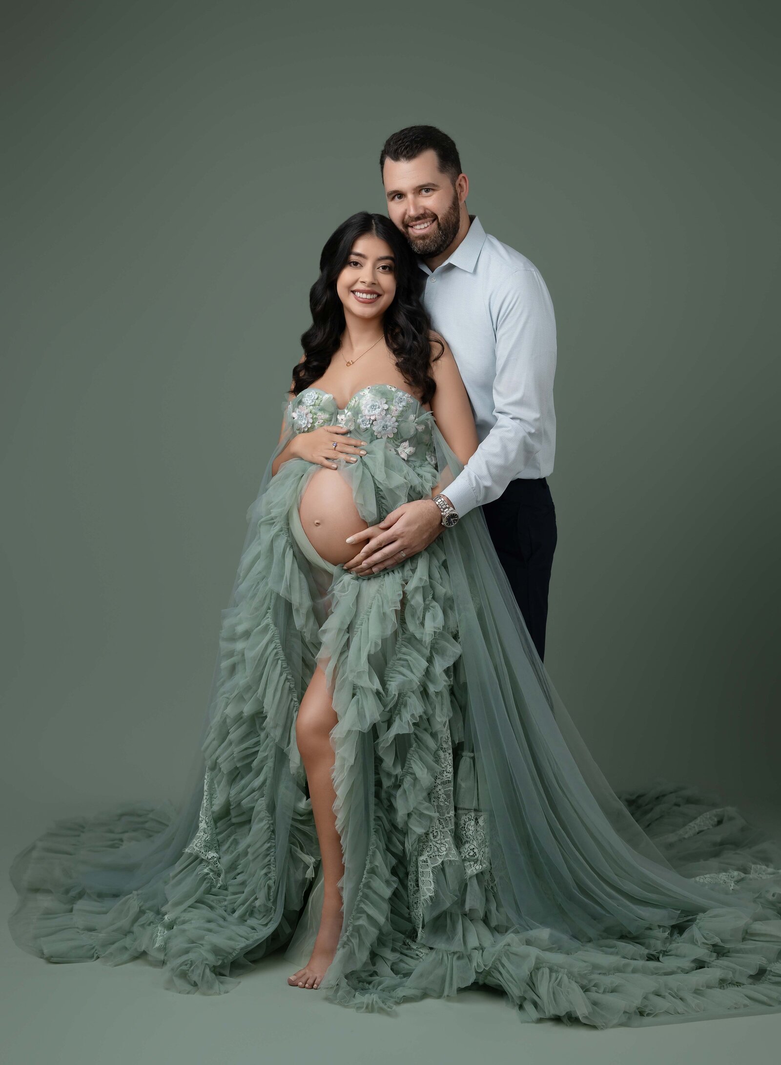 Mom and dad holding baby bump and smiling at camera. Pregnancy photo taken by Jenni. Nikki Photography at Atlanta Photo Studio. 