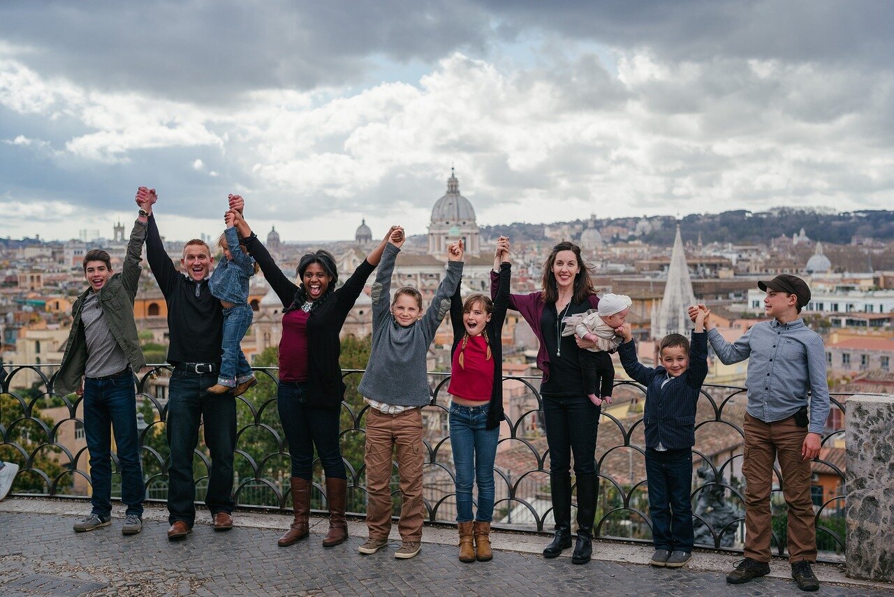 Family traveling photo in front of a tower