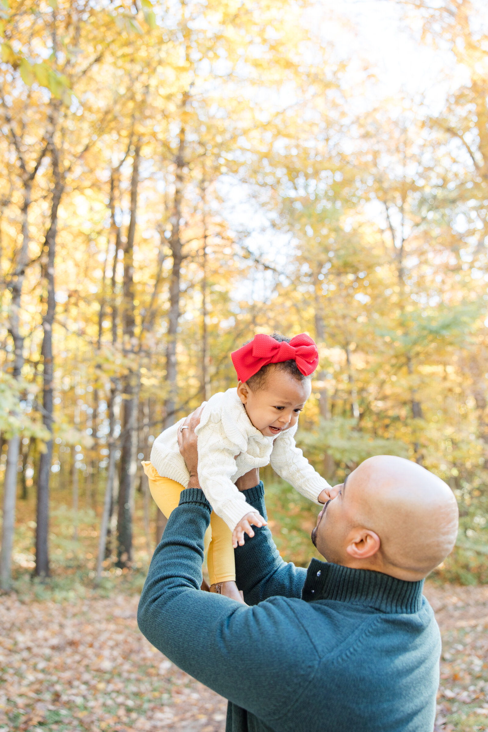 dad tossing baby girl in the air  photographed by Kaitlin Mendoza Photography, a family photographer in Carmel, Indiana