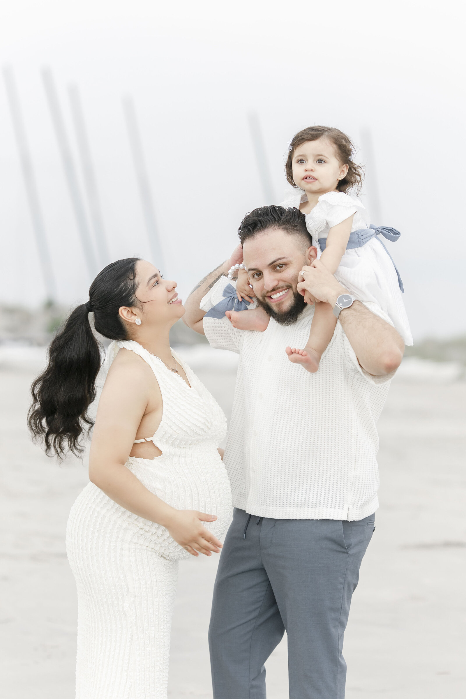 family of three mom holding pregnant belly photographed by ocean city family photographer 