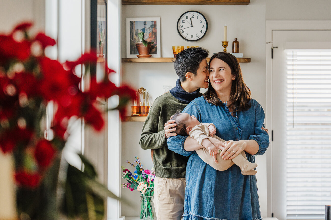 moms stand in kitchen with new baby girl