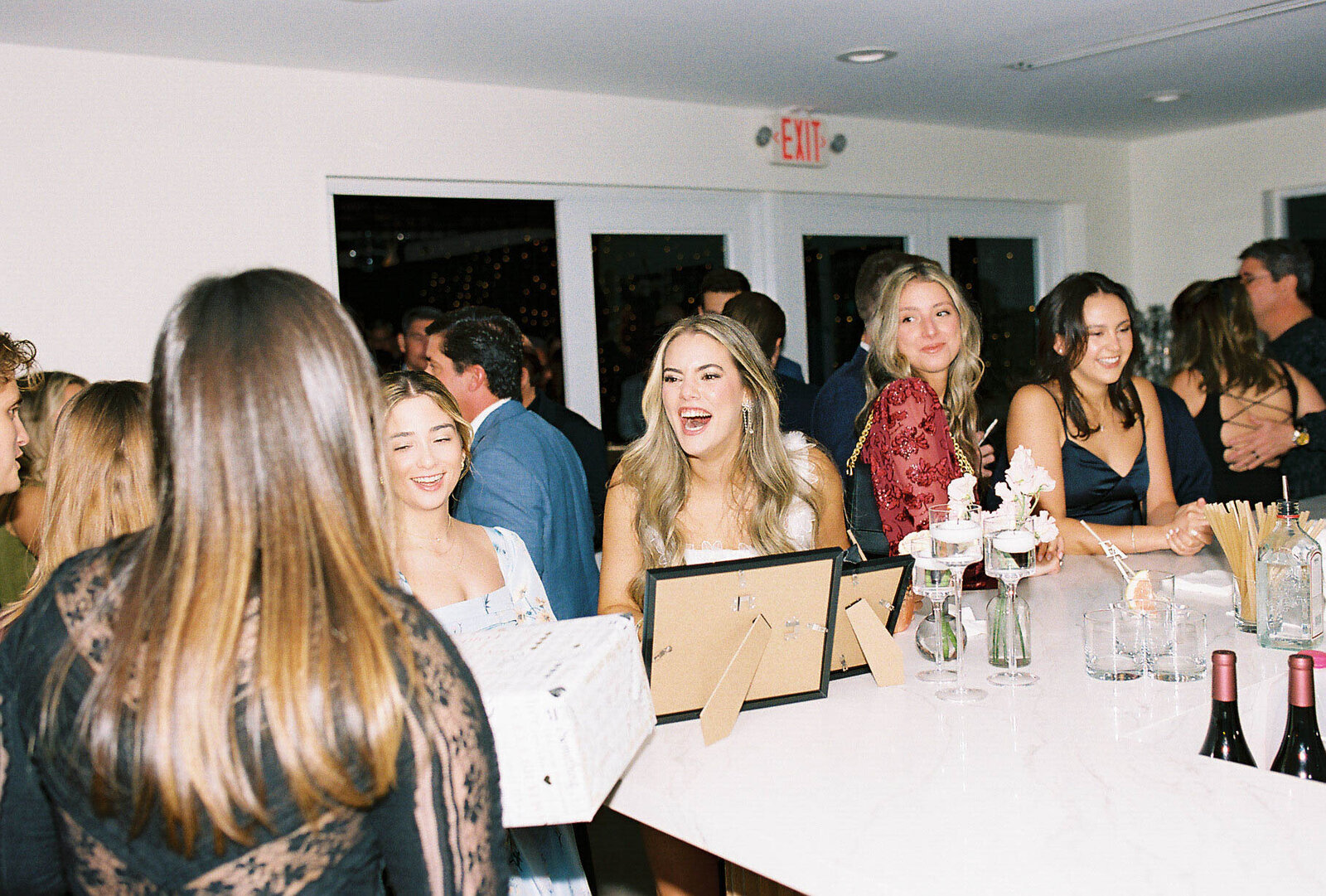 Bride and guests enjoying their time at the wedding reception at the bar